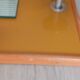 1950s coat rack with mirror, metal hooks, and glass shelf.
