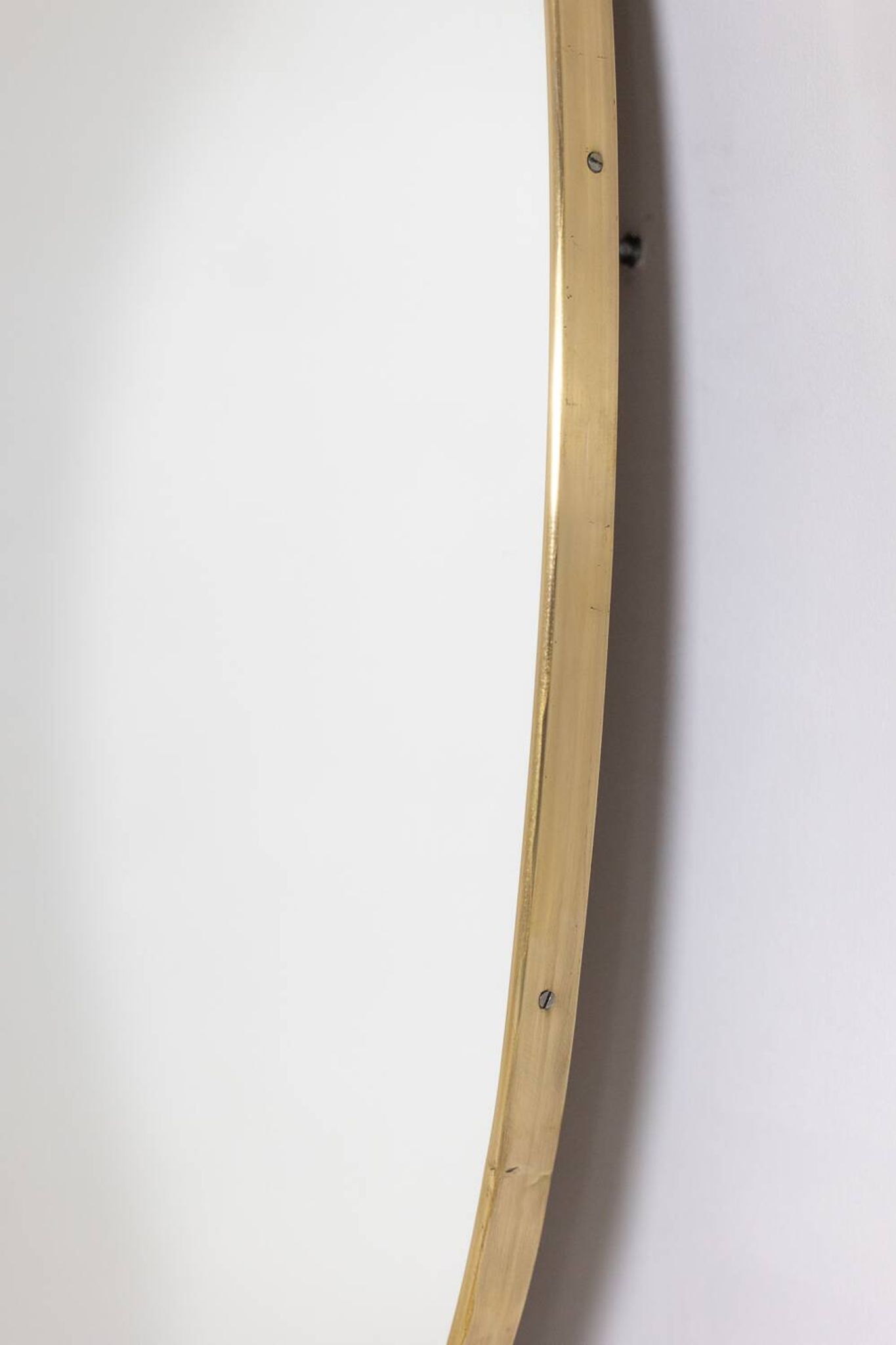 Oval shaped mirror set with a gilded brass rod. 1970s.