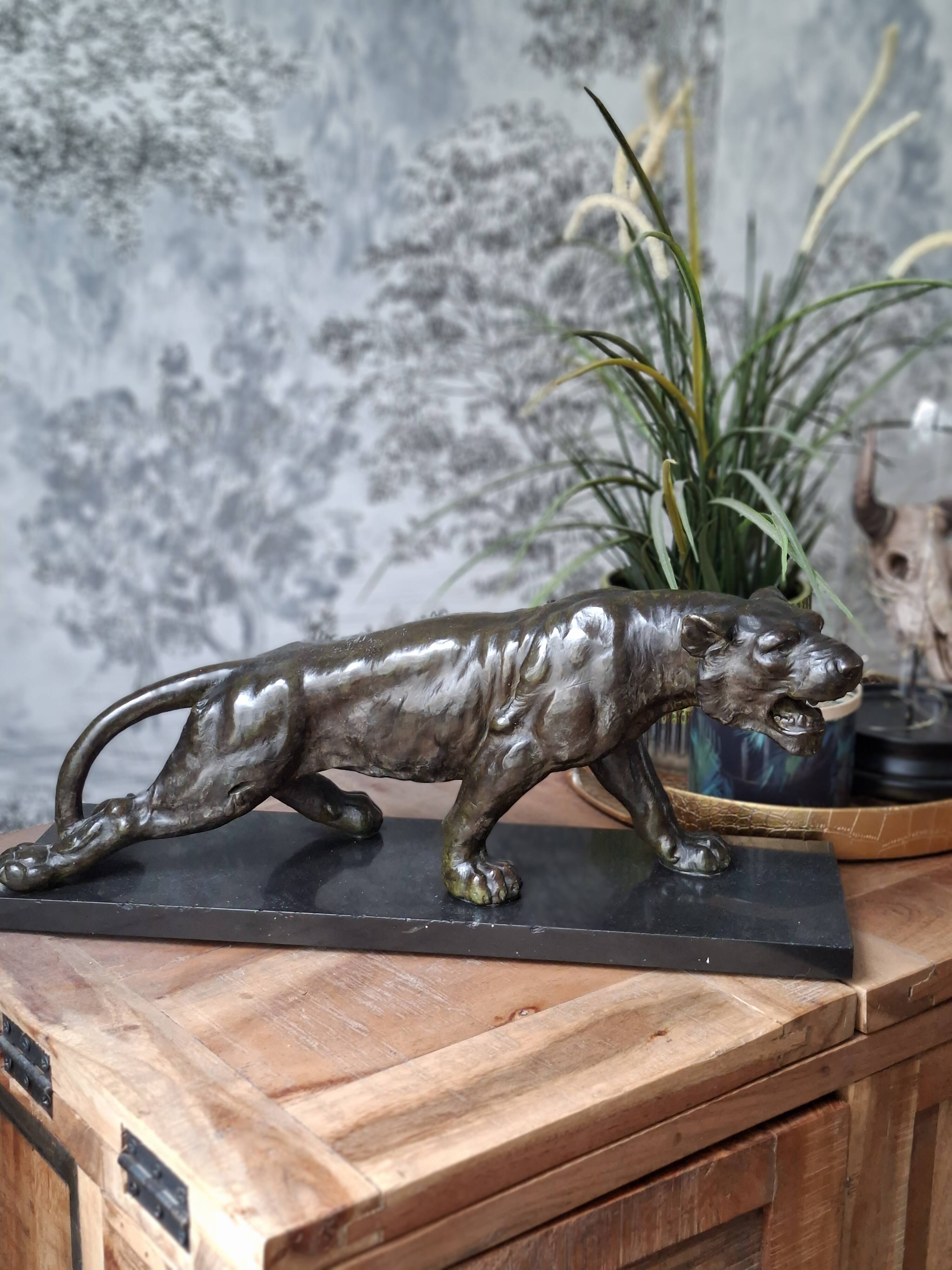 Bronze patinated panther on a black marble base – French work from the 20th century.