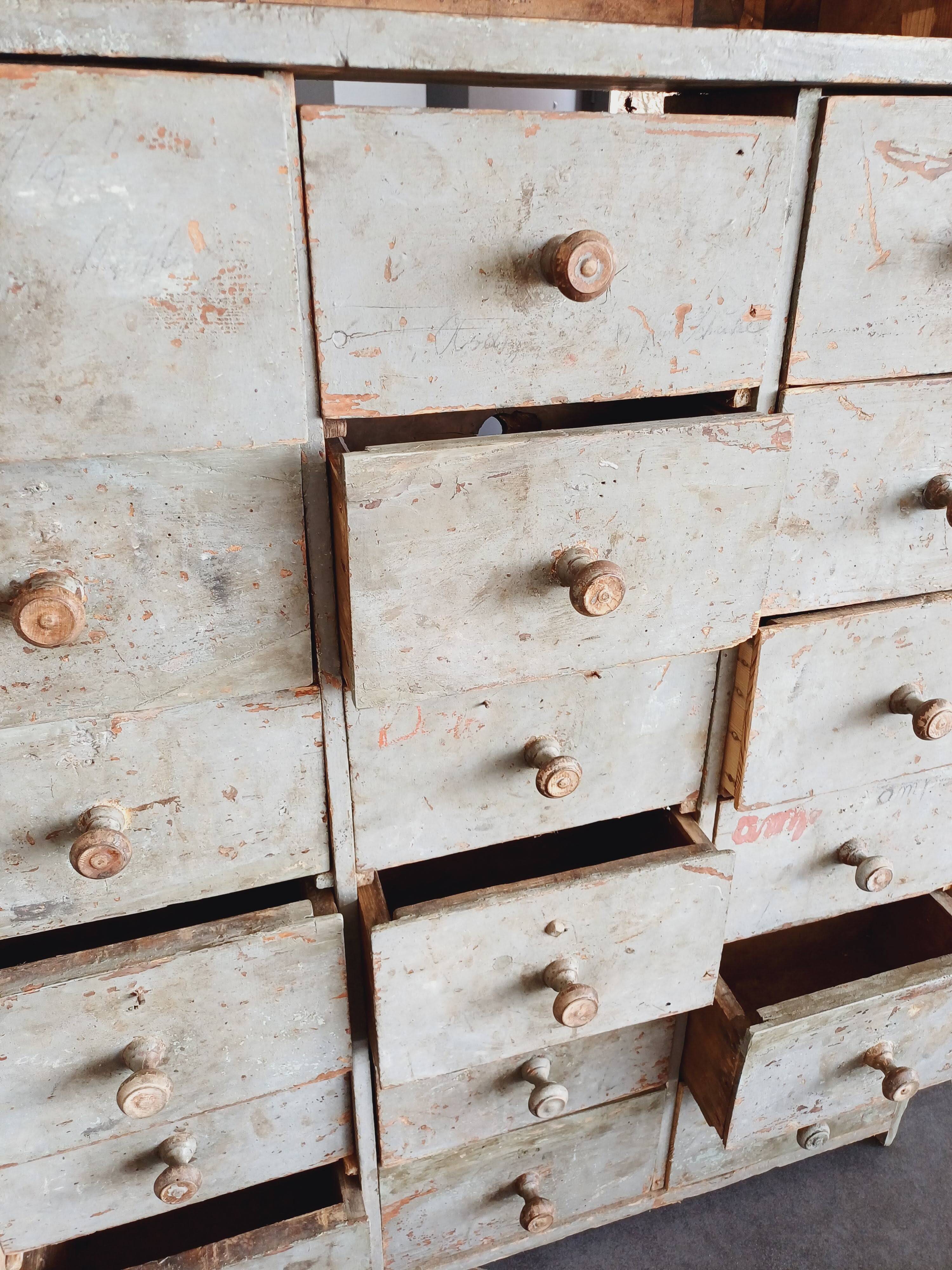 Craft cabinet with drawers with a very old tobacco advertisement in the background