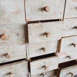 Craft cabinet with drawers with a very old tobacco advertisement in the background