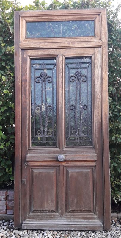 Oak entrance door and its frame and transom, wrought iron gates