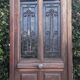 Oak entrance door and its frame and transom, wrought iron gates