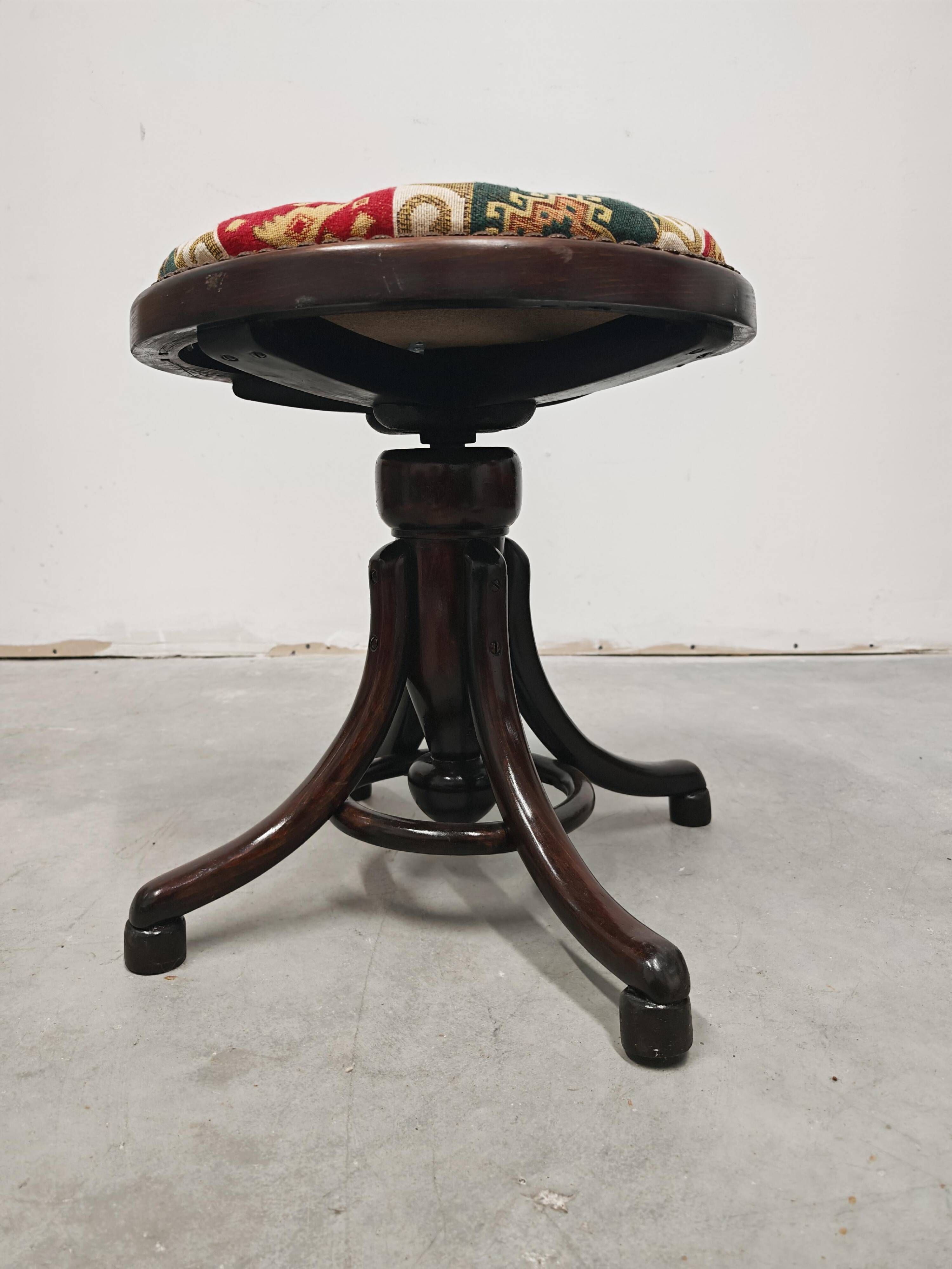 Antique curved wooden piano stool with kilim fabric from the 1910s.