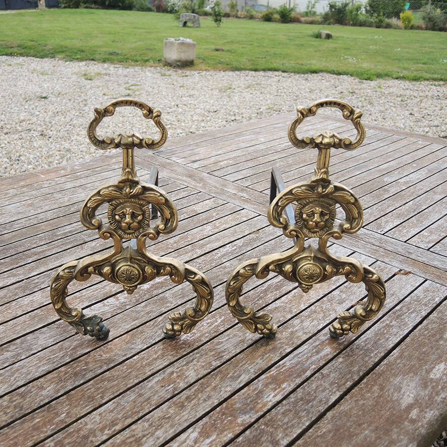 Antique brass andirons with lion decoration