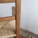 Vintage wooden high chair for children with a straw seat.