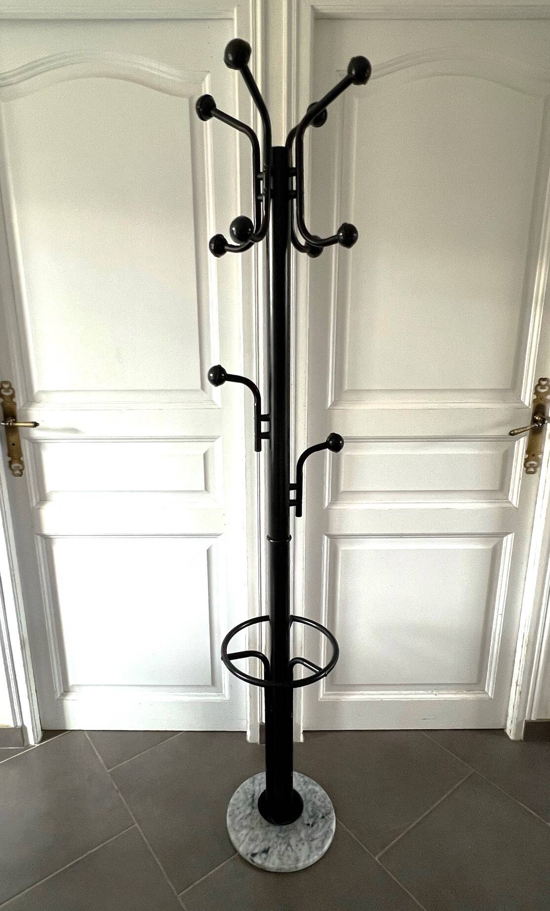 Black metal parrot coat rack on marble base