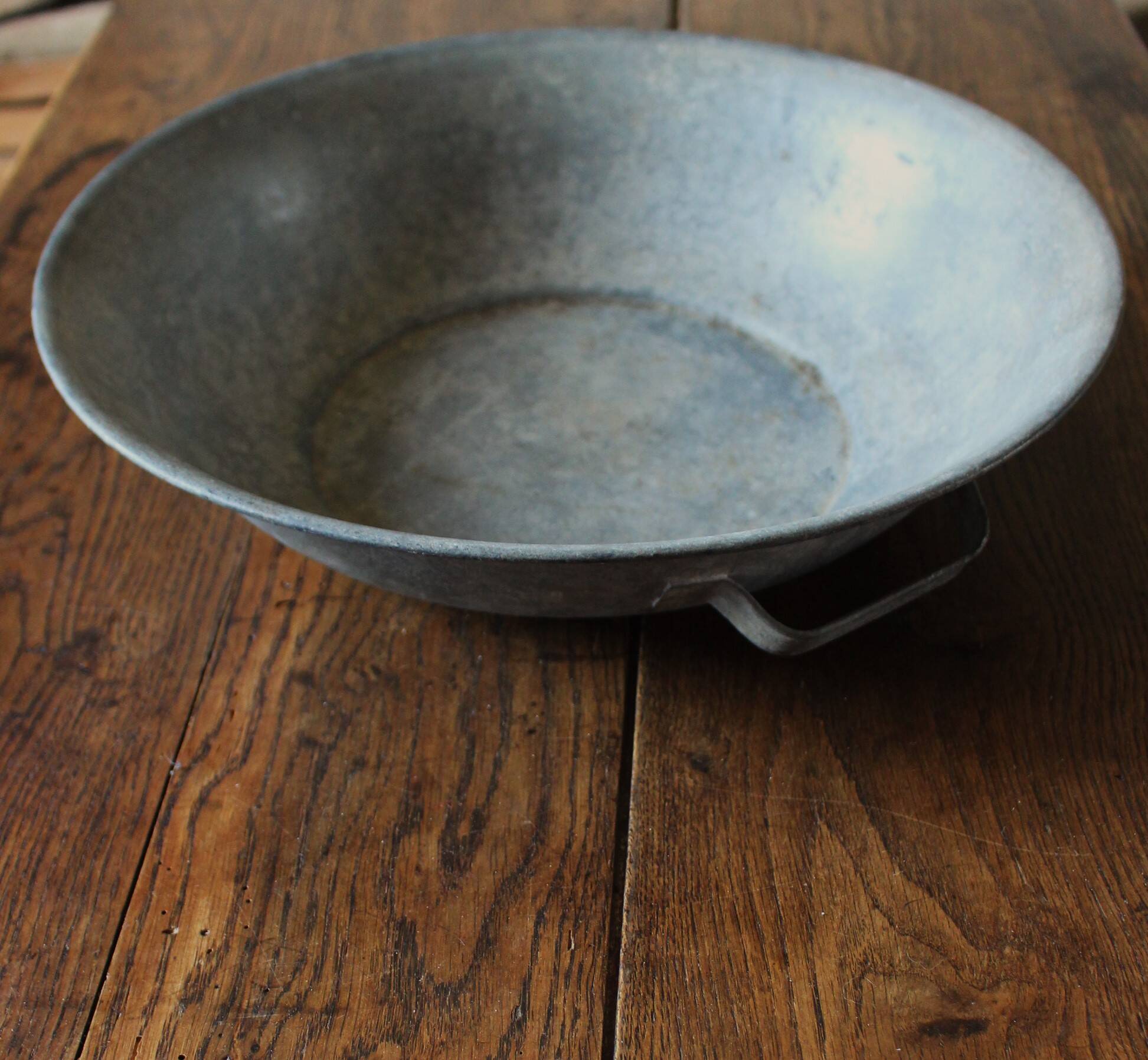 Round zinc basin planter with two handles underneath