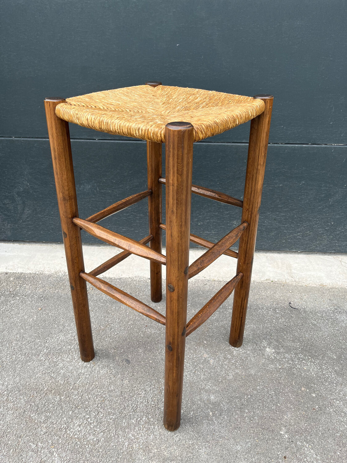 Old high bar stool in wood and straw