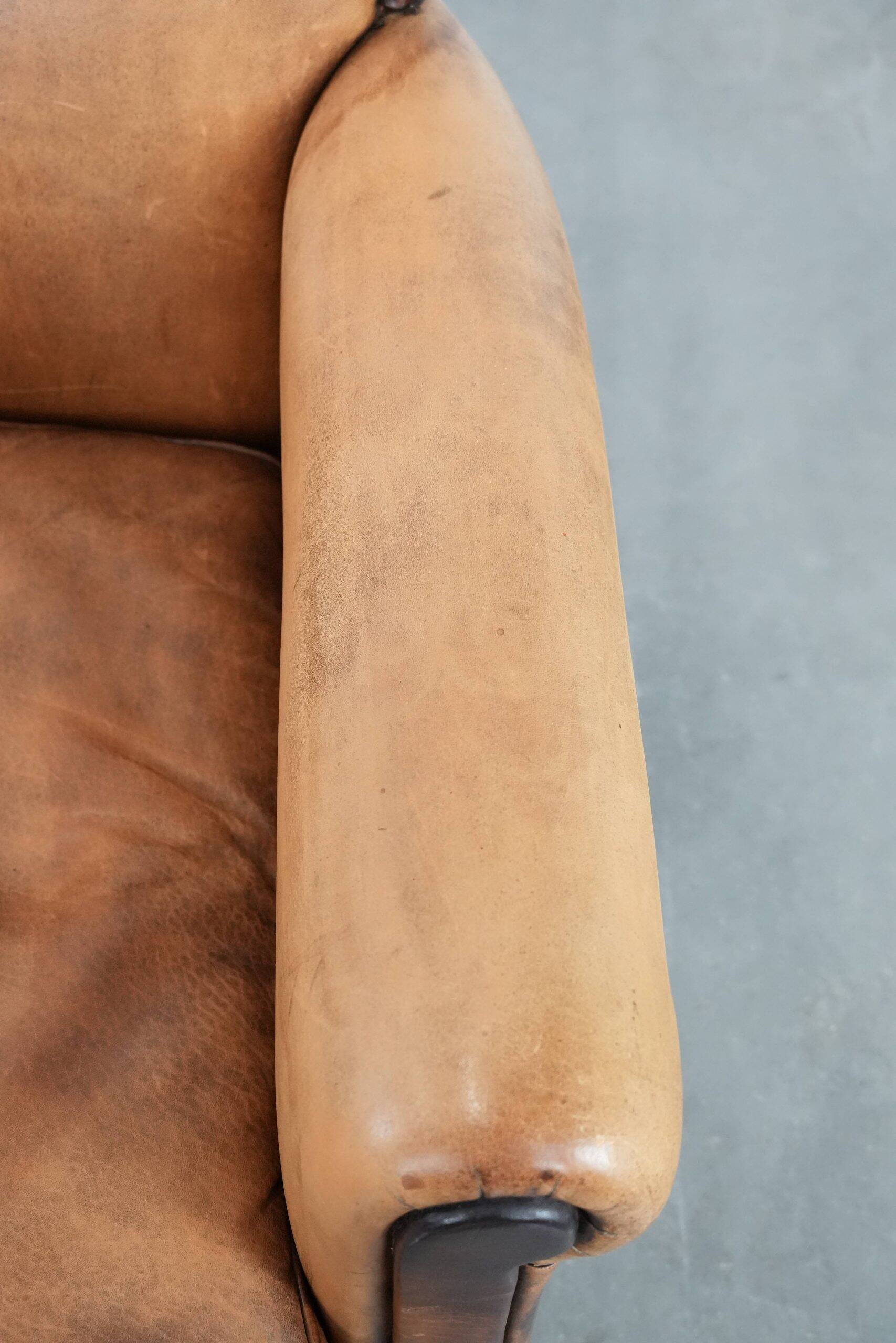 Vintage sheepskin armchair with a beautiful light colour and elegant legs