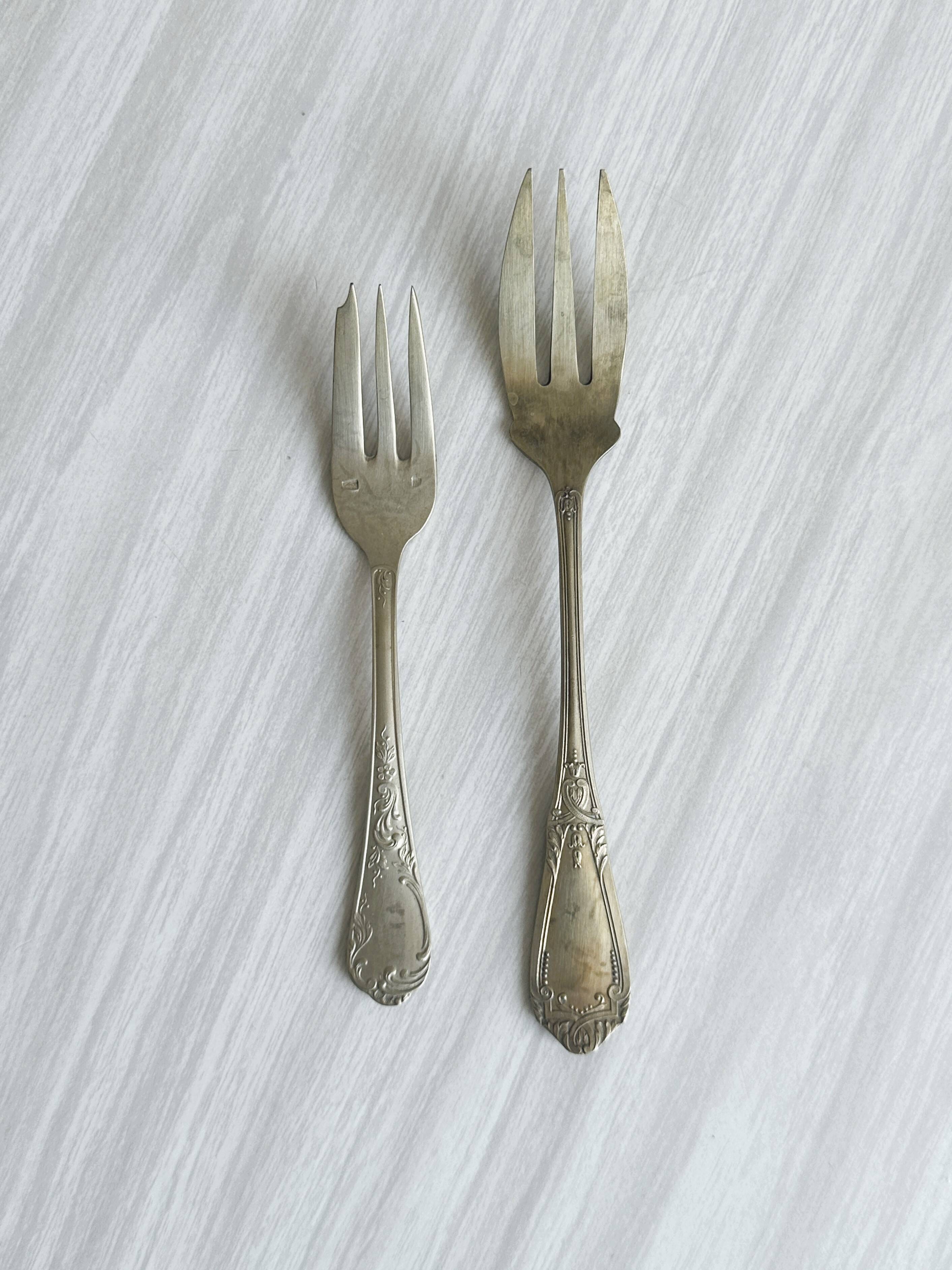 Paire de fourchettes en métal argenté, design orné