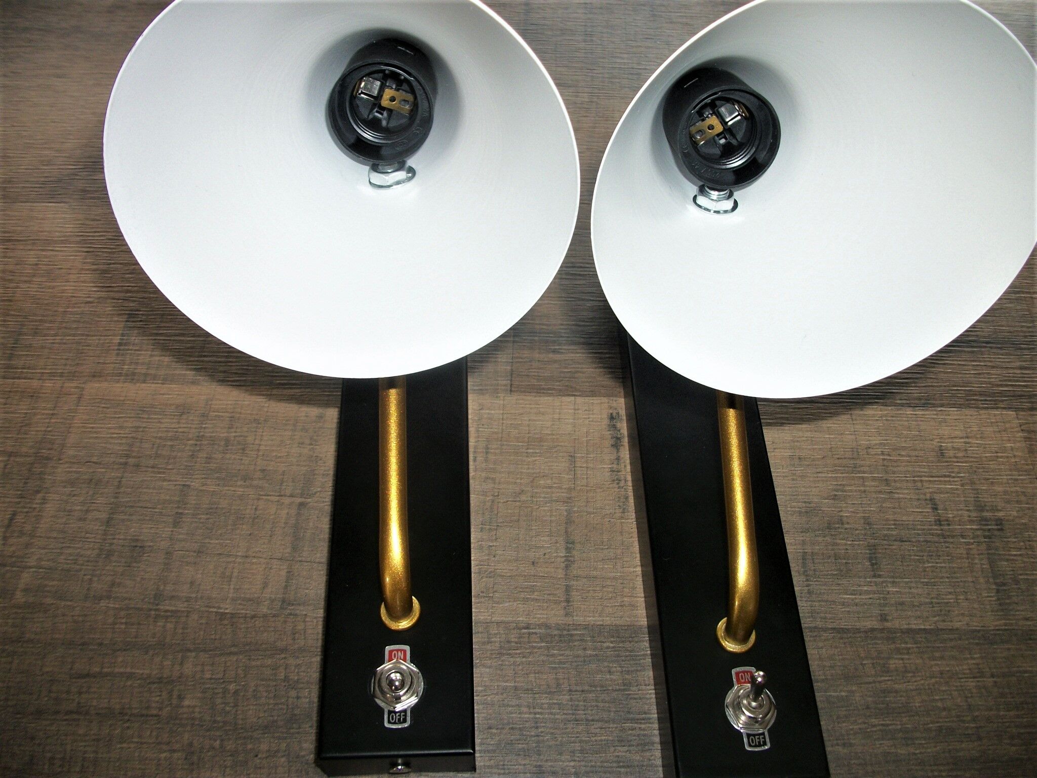 Pair of modernist sconces in black and gold metal