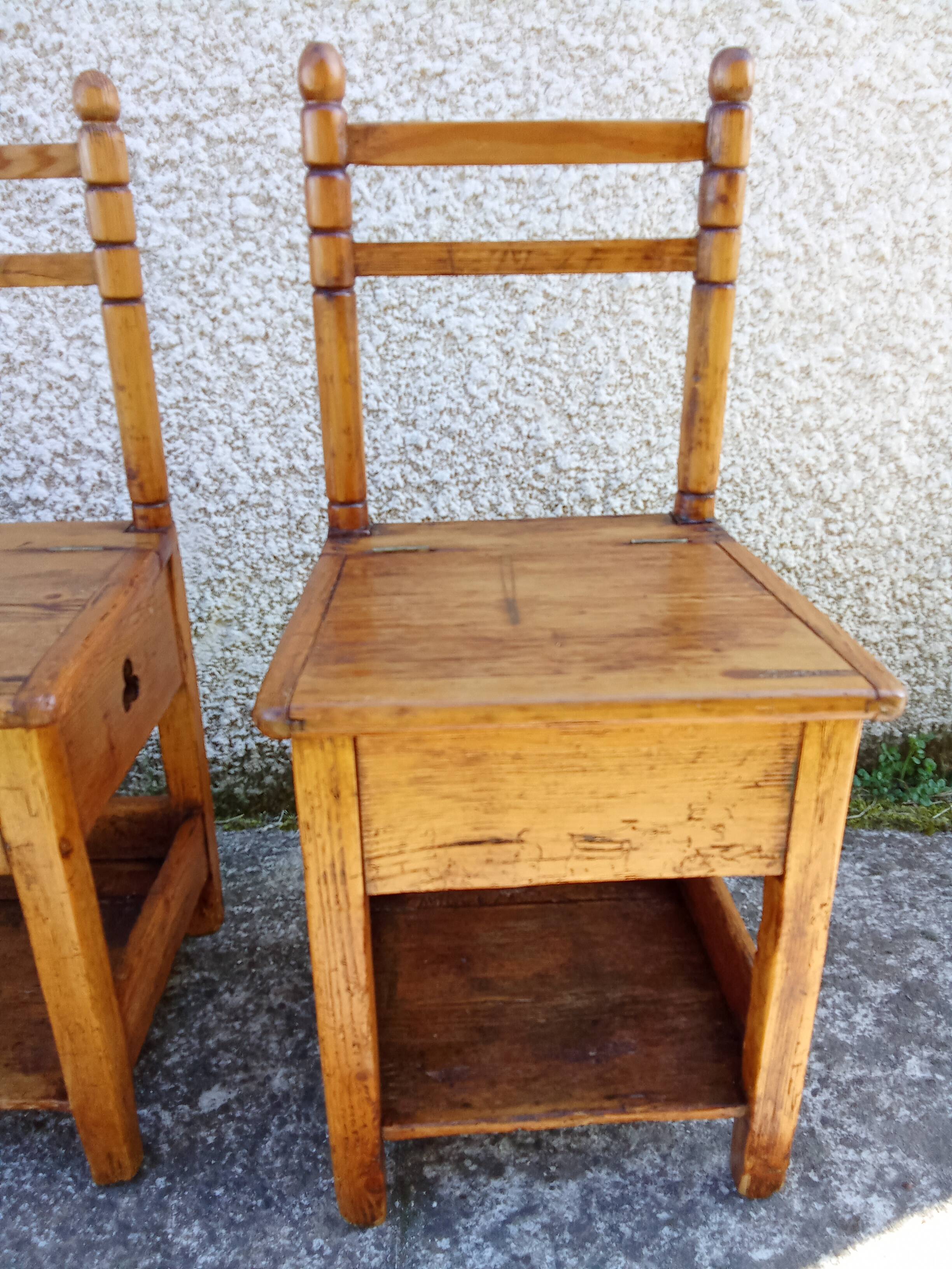 2 old wooden children's chairs with a small chest.
