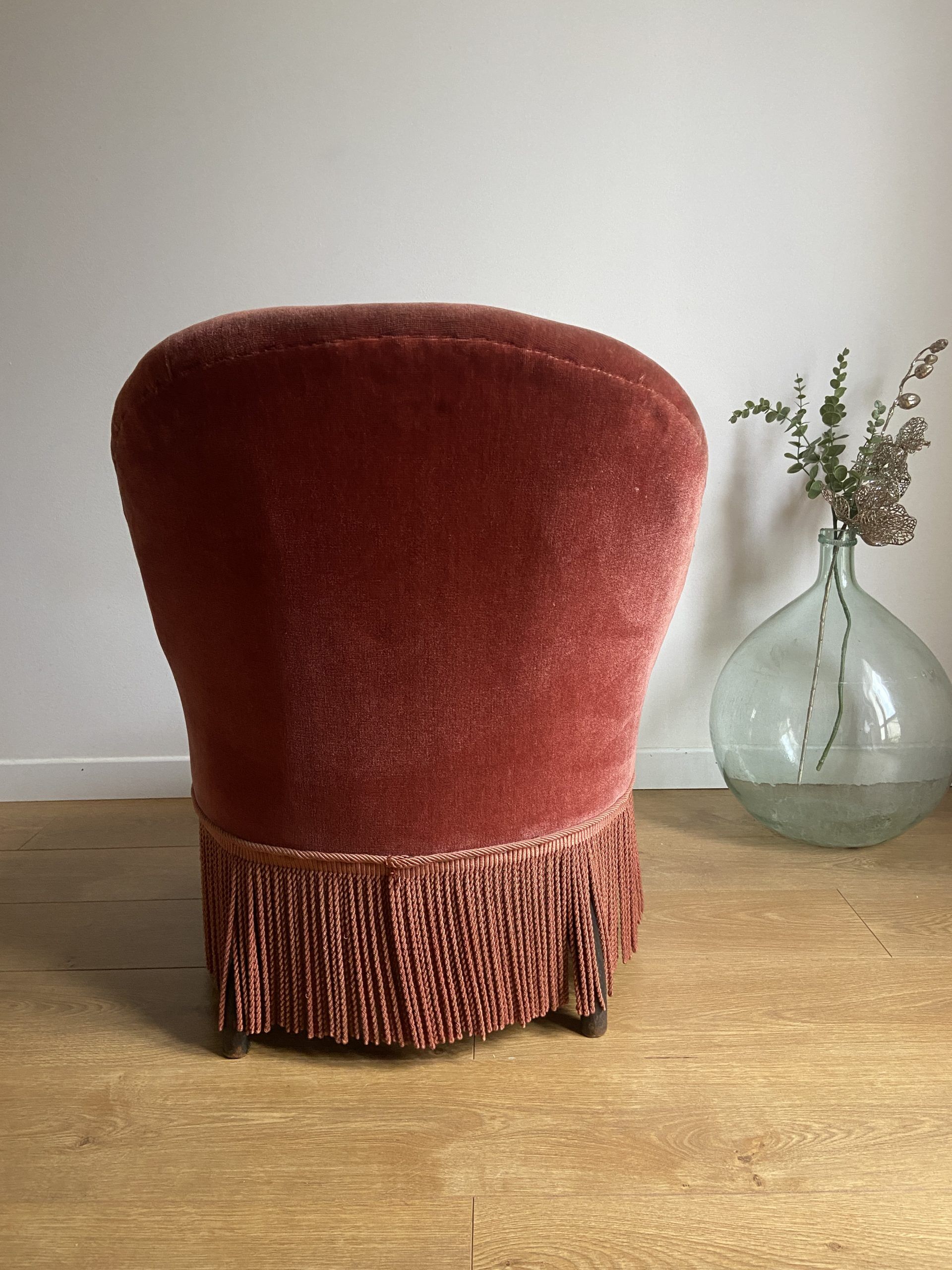 Fauteuil crapaud vintage rose framboise en velours à franges