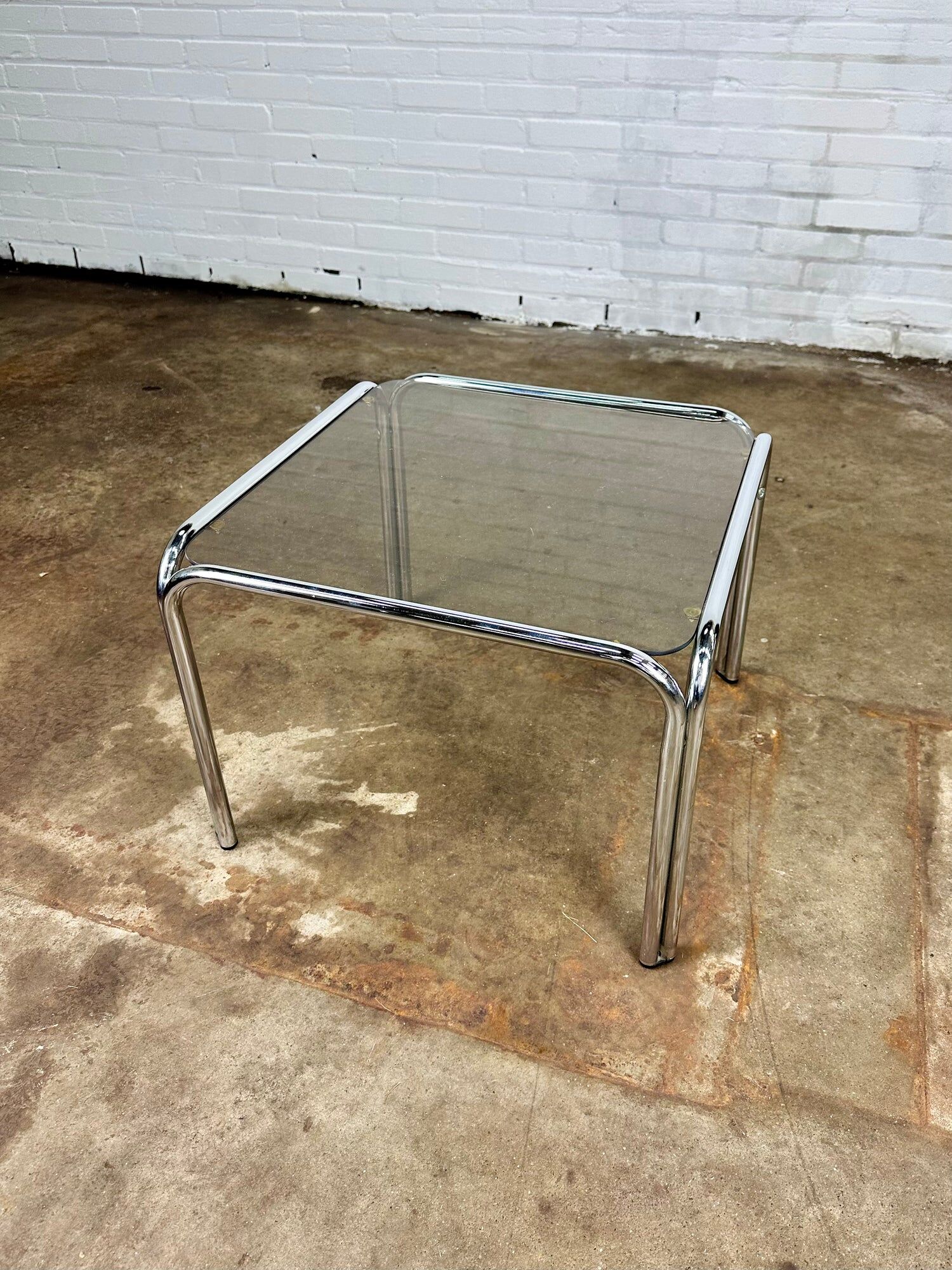 Table basse vintage en métal chromé et verre fumé