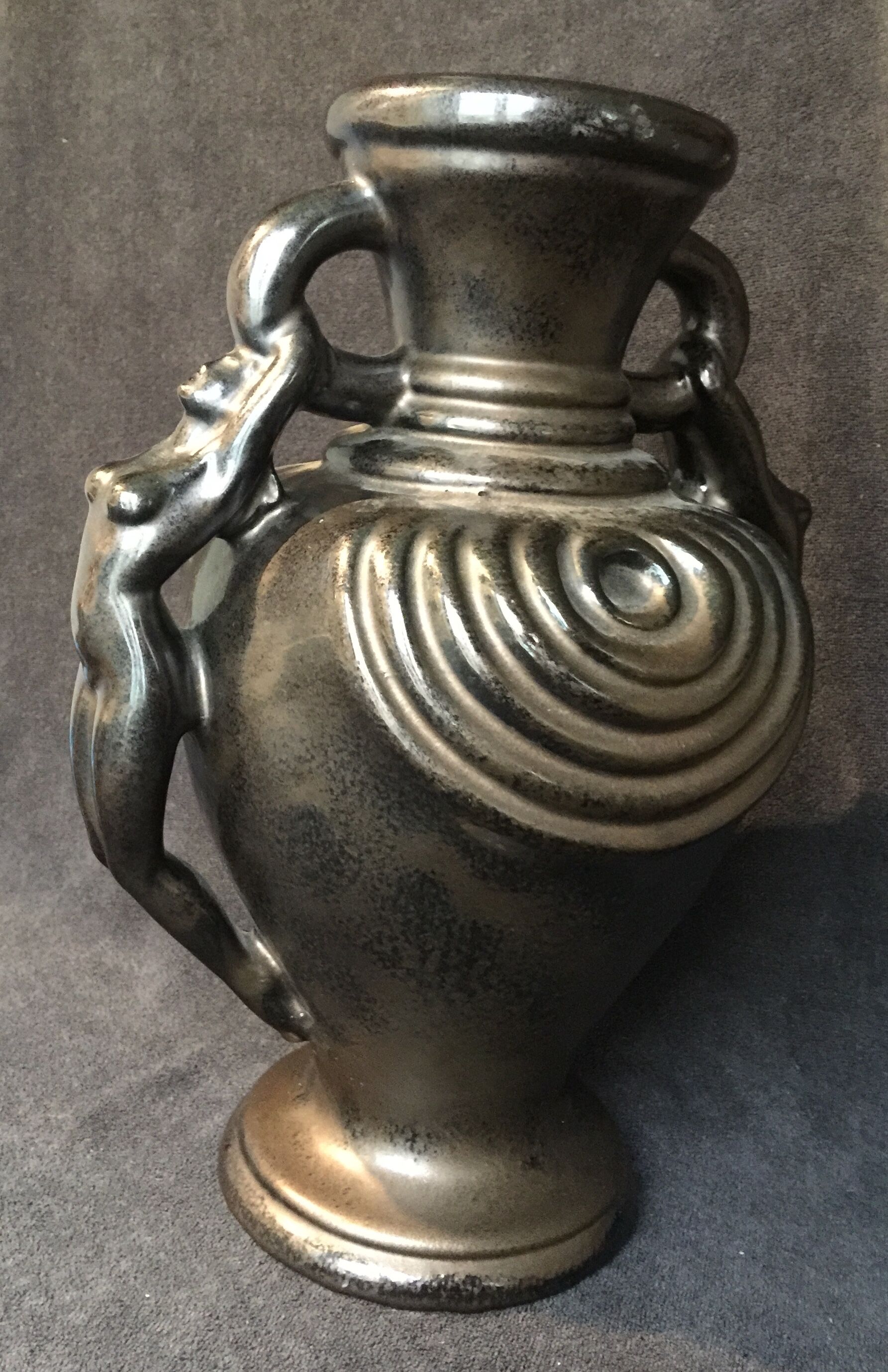 Black ceramic vase caught in naked women's bodies