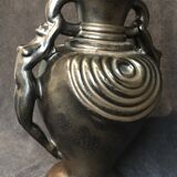 Black ceramic vase caught in naked women's bodies