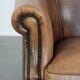 Club chair made of sheepskin leather finished with decorative nails