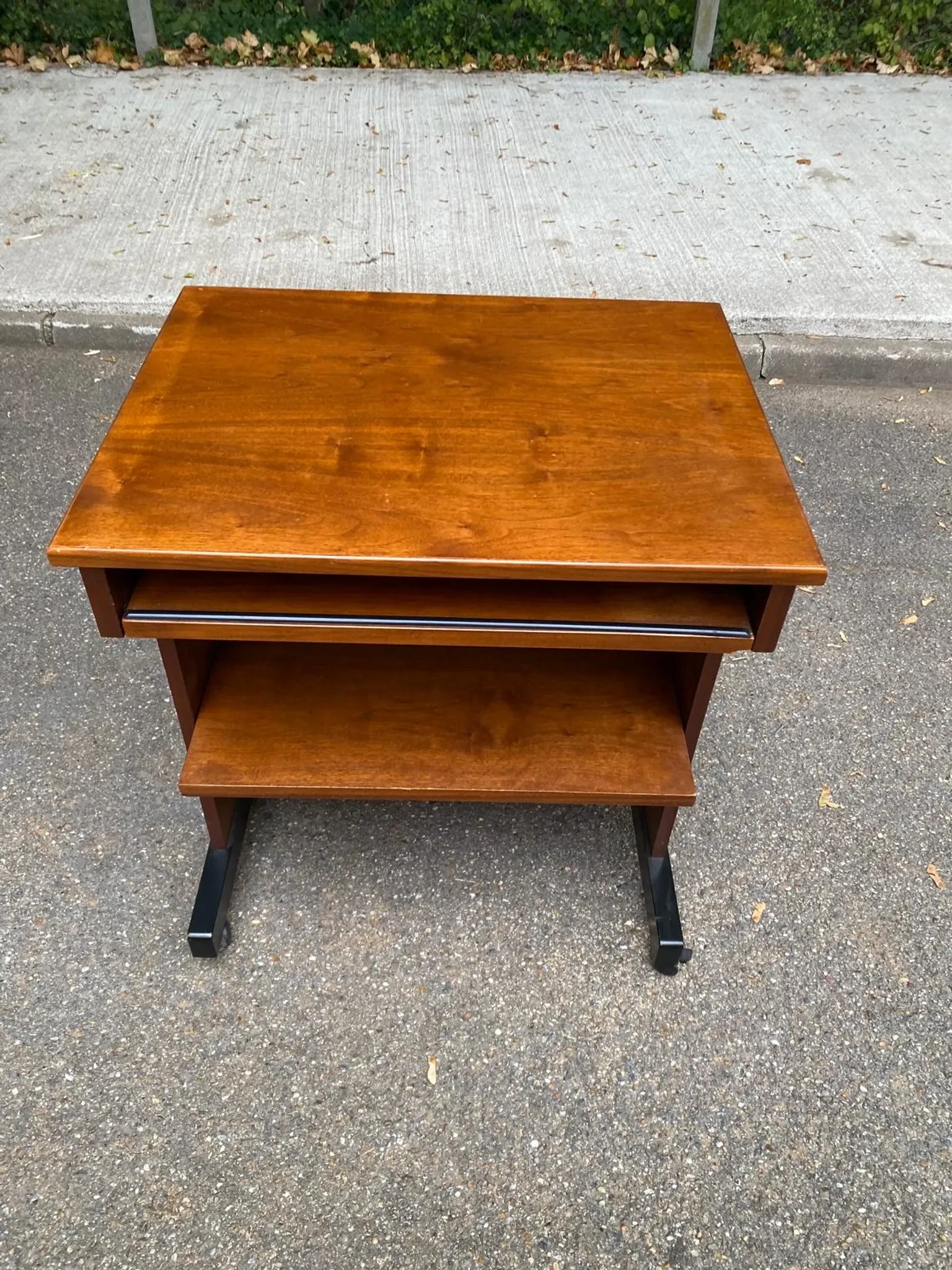 Small Scandinavian-style computer desk on wheels made of wood.