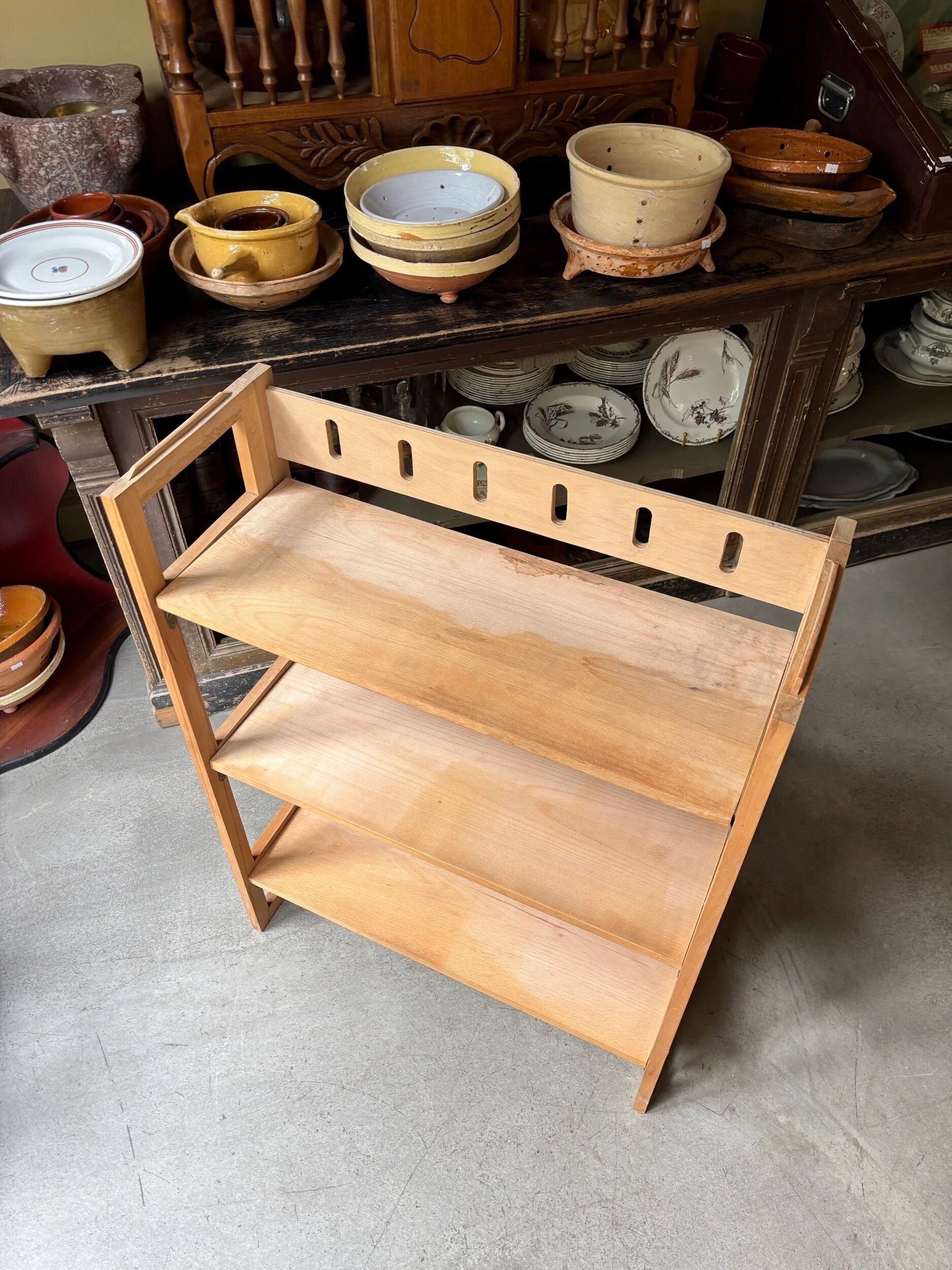 Folding bookshelf in light wood.