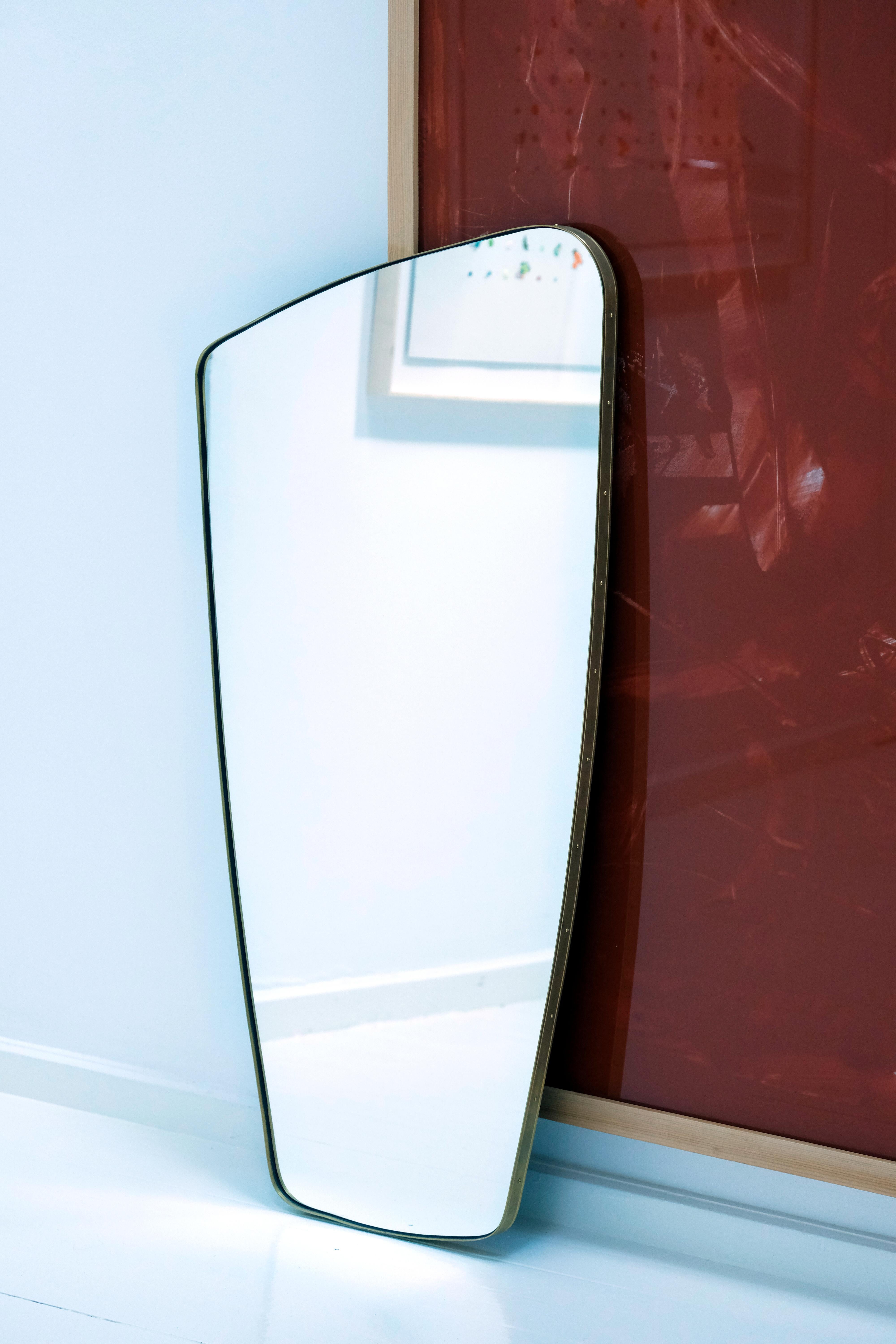 Contemporary rectangular mirror with rounded edges and embossed brass frame.
