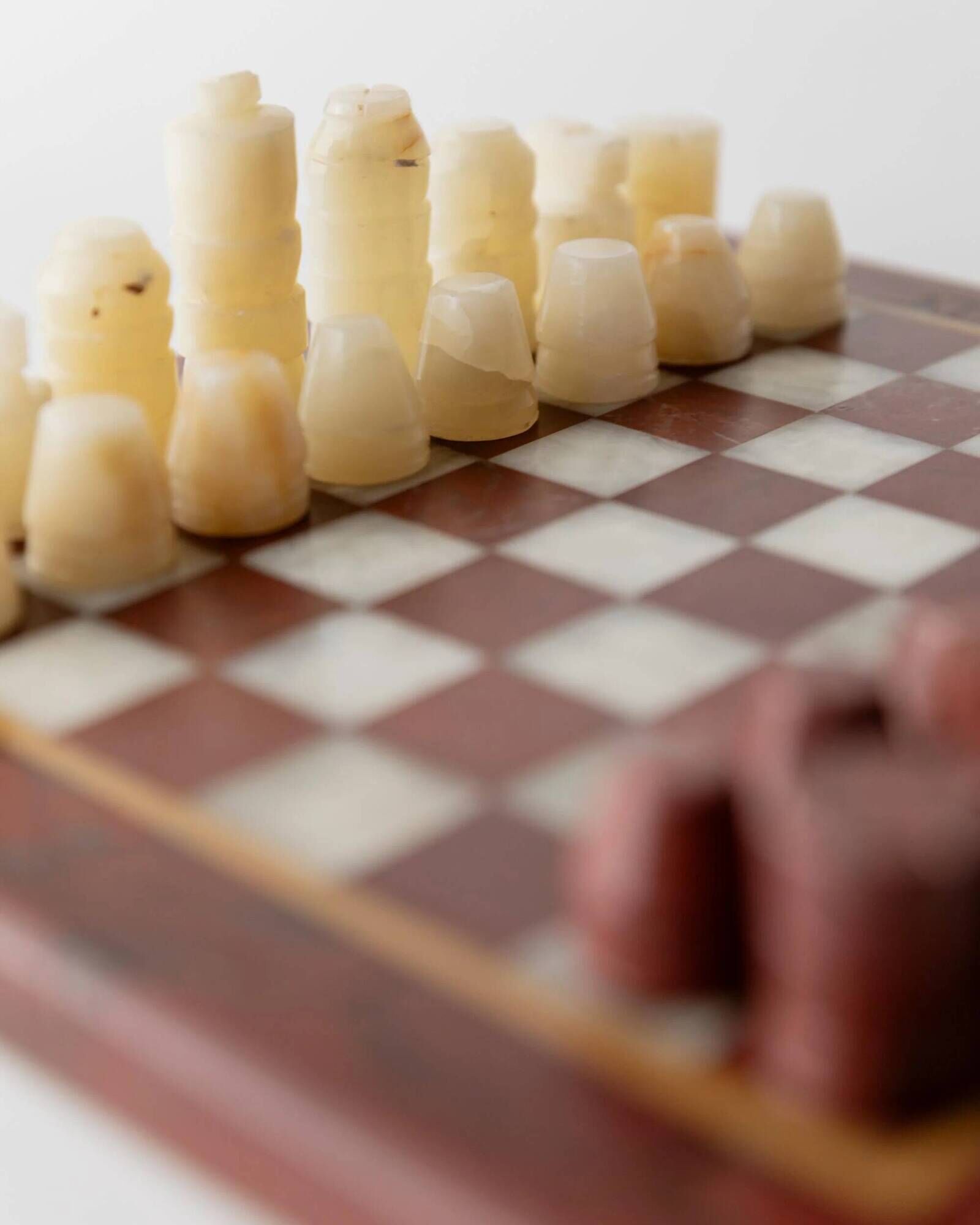Vintage marble chess set from the 1960s, cream, burgundy and gold board with metal inlay, stone pieces.