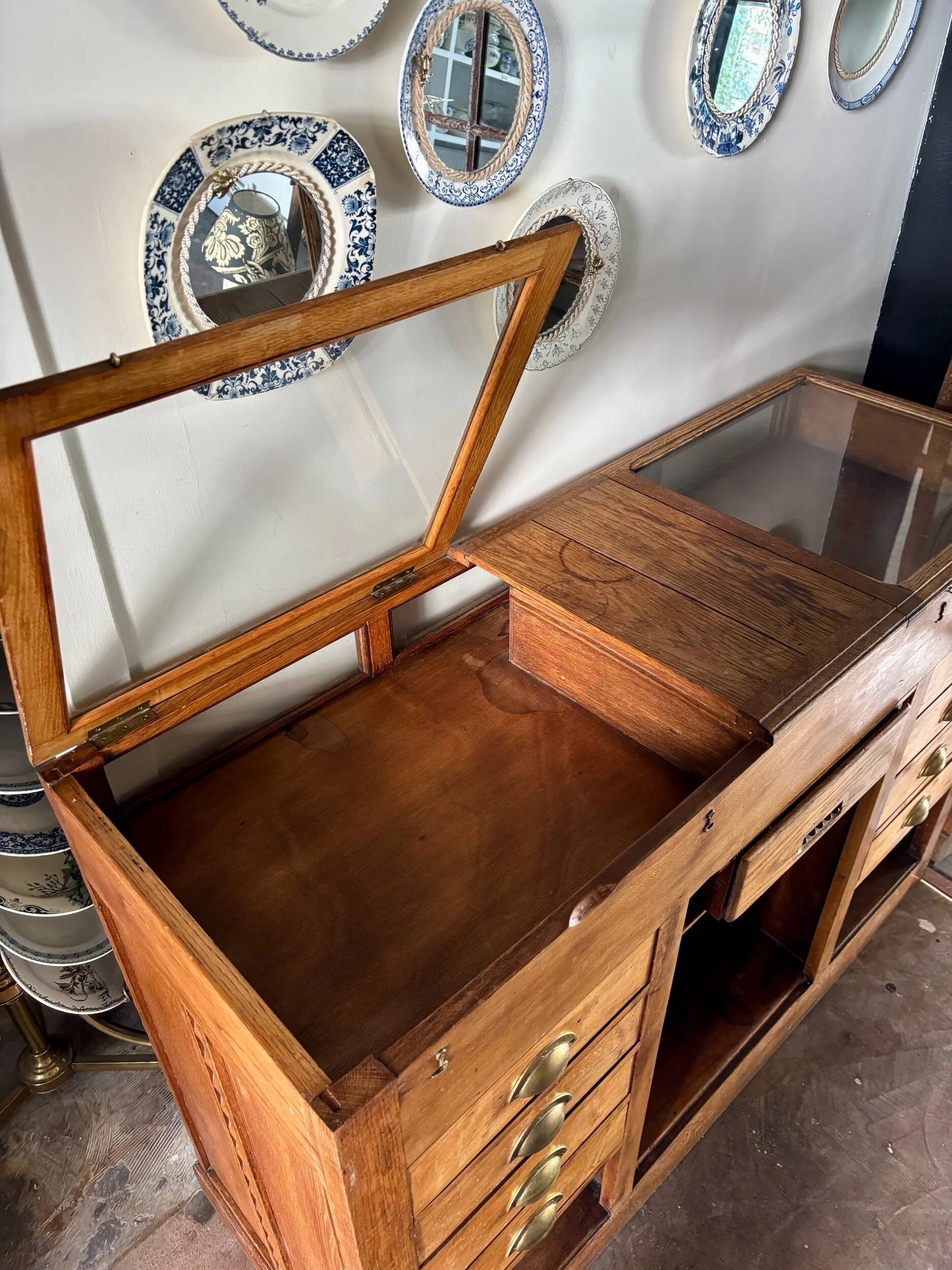 Counter, glass-fronted wooden workbench in dark wood, 8 drawers.