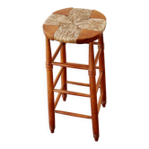 Antique wooden bar stool with a straw seat