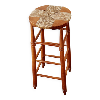 Antique wooden bar stool with a straw seat
