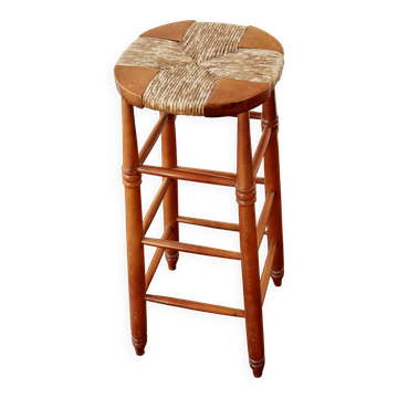 Antique wooden bar stool with a straw seat