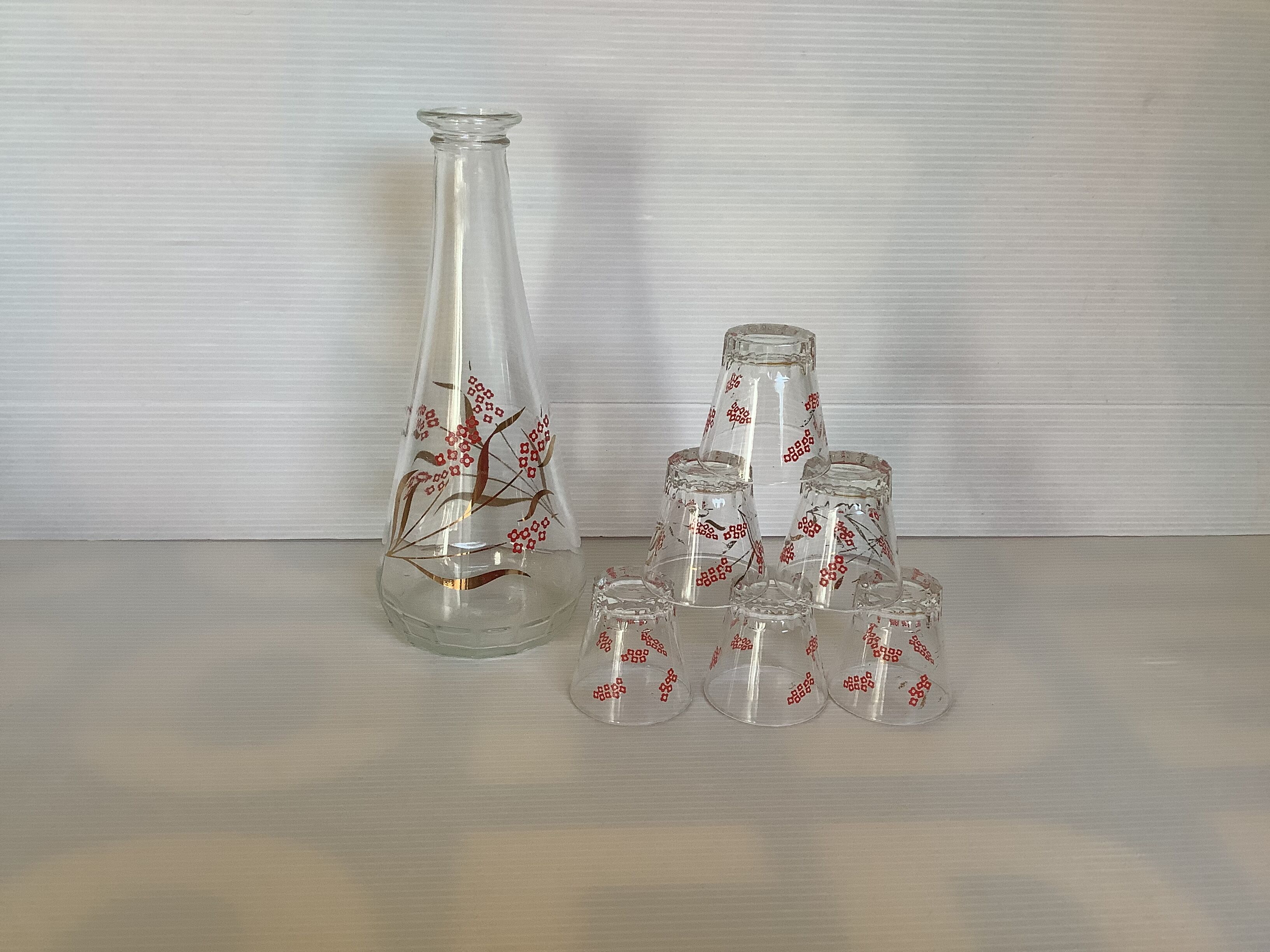 Carafe and 6 matching glasses in red and gold.