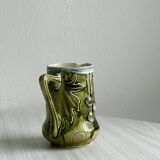 Green slip milk jug with floral patterns.