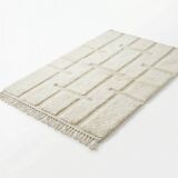 Berber rug with a white graphic pattern.