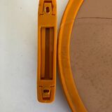 Tilting orange plastic mirror with its matching wall light