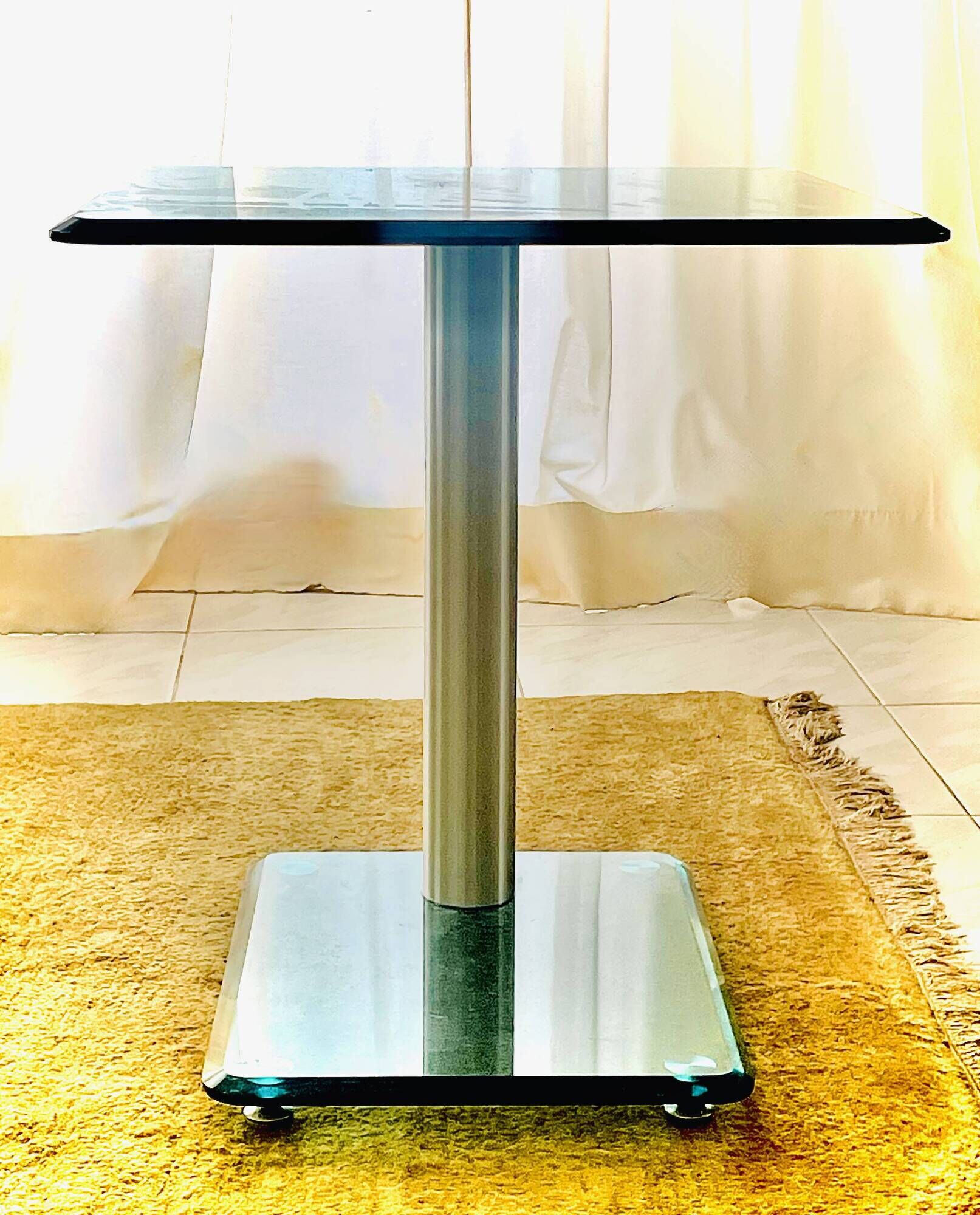 Contemporary square side table in glass with a metallic central column.