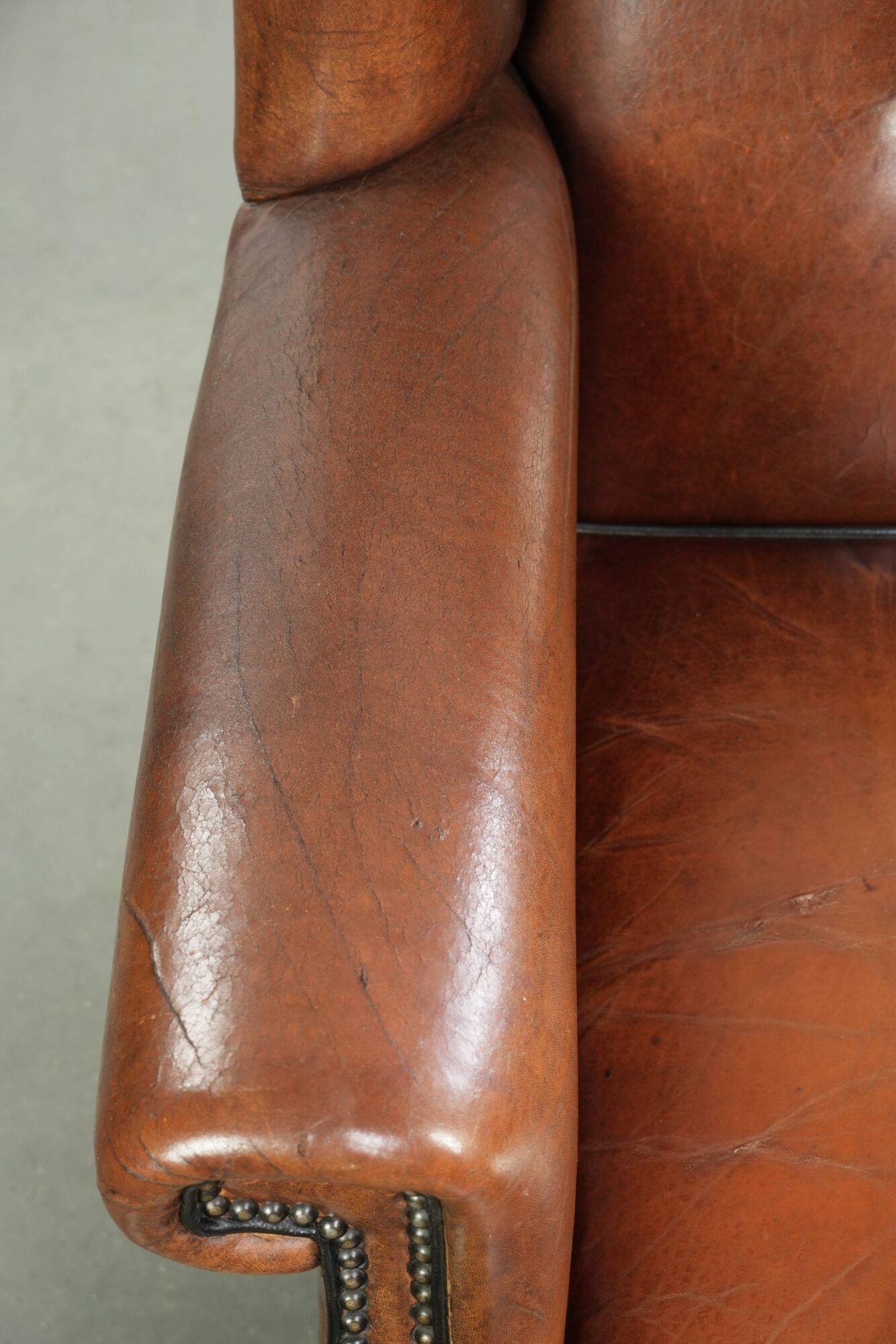 Sheepskin wingback armchair finished with black piping and a correct seat