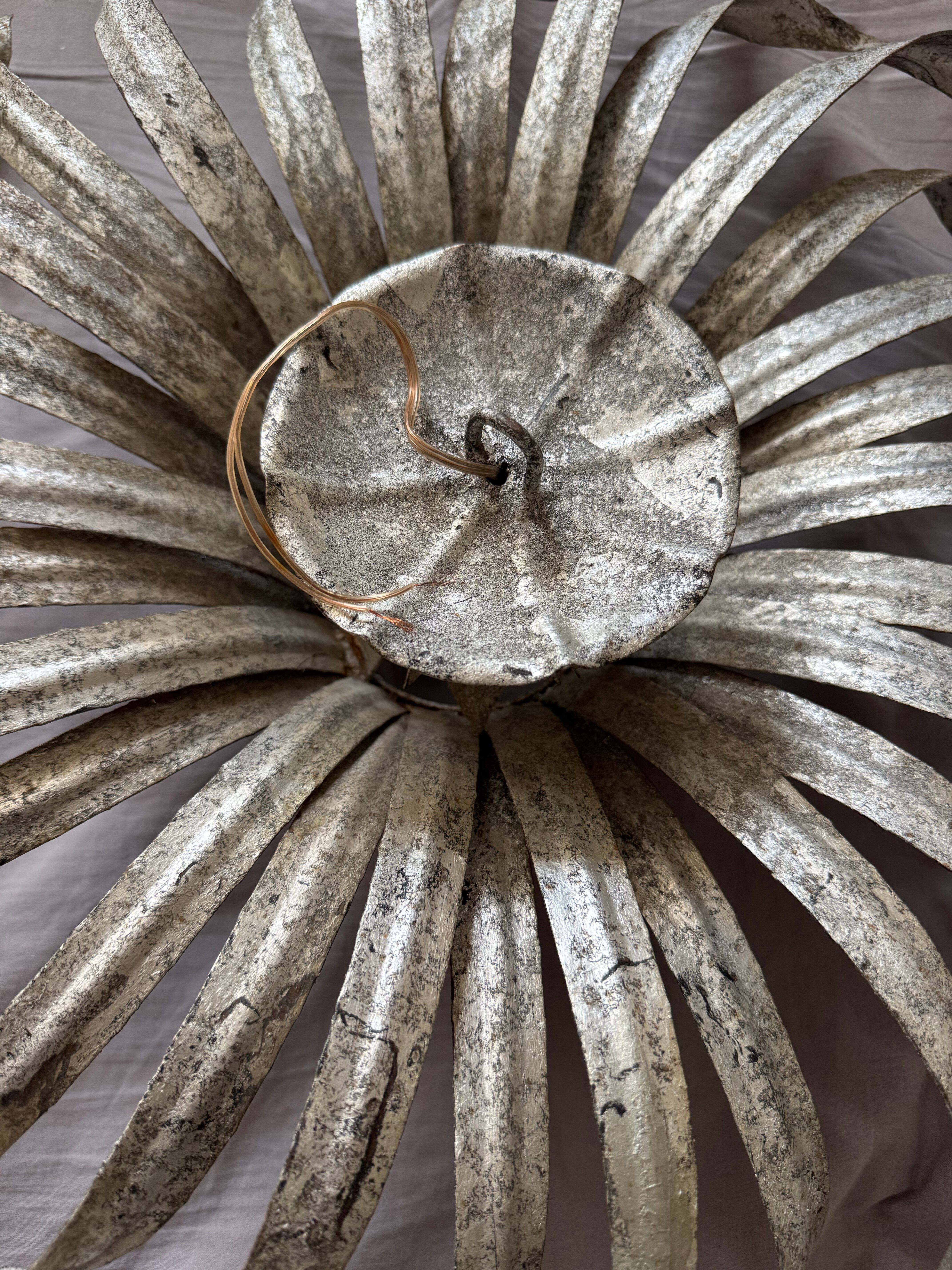 Silver wrought iron sunburst wall light from the 1960s.