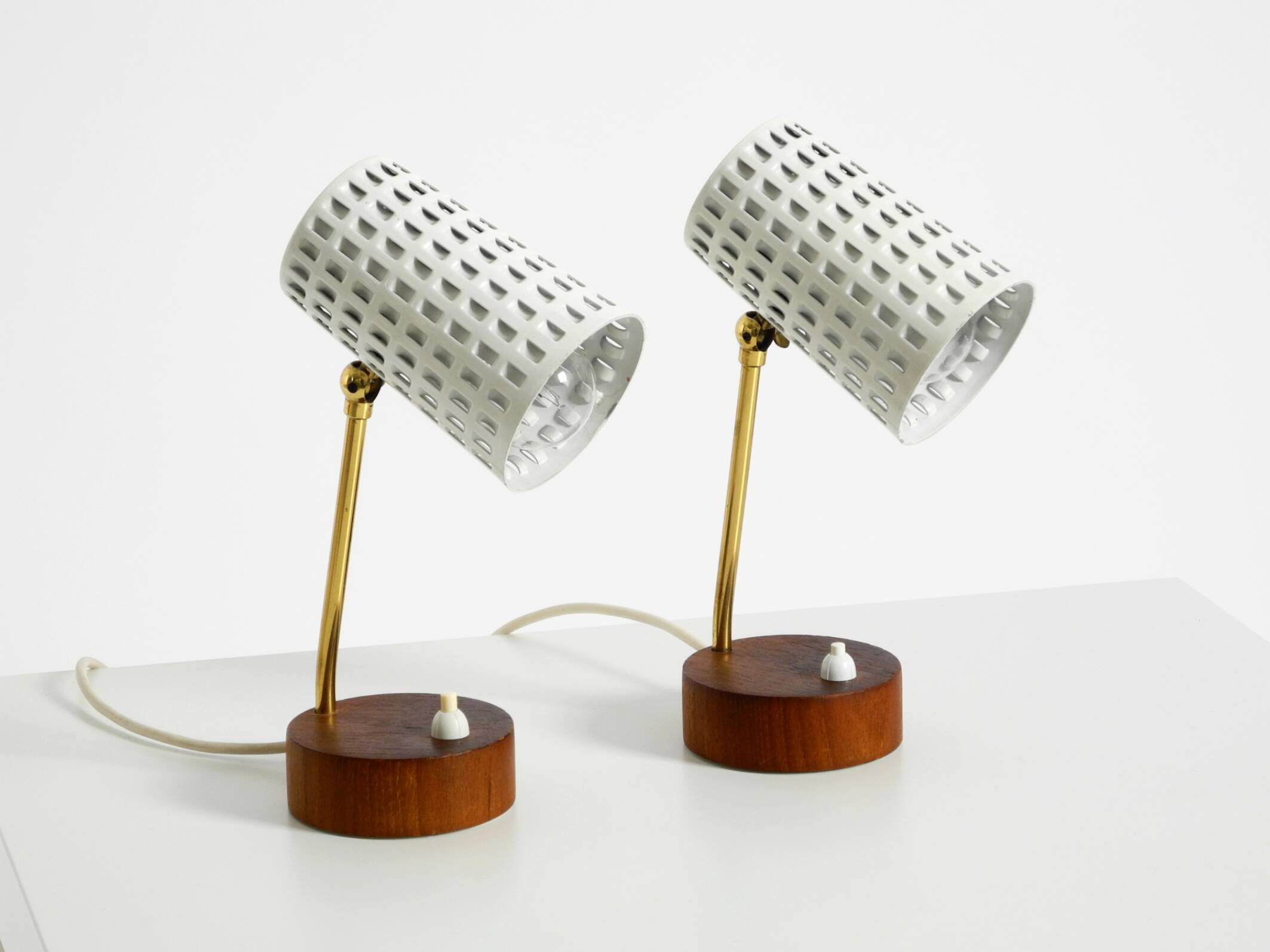 A pair of mid-century modern bedside lamps with perforated metal shades