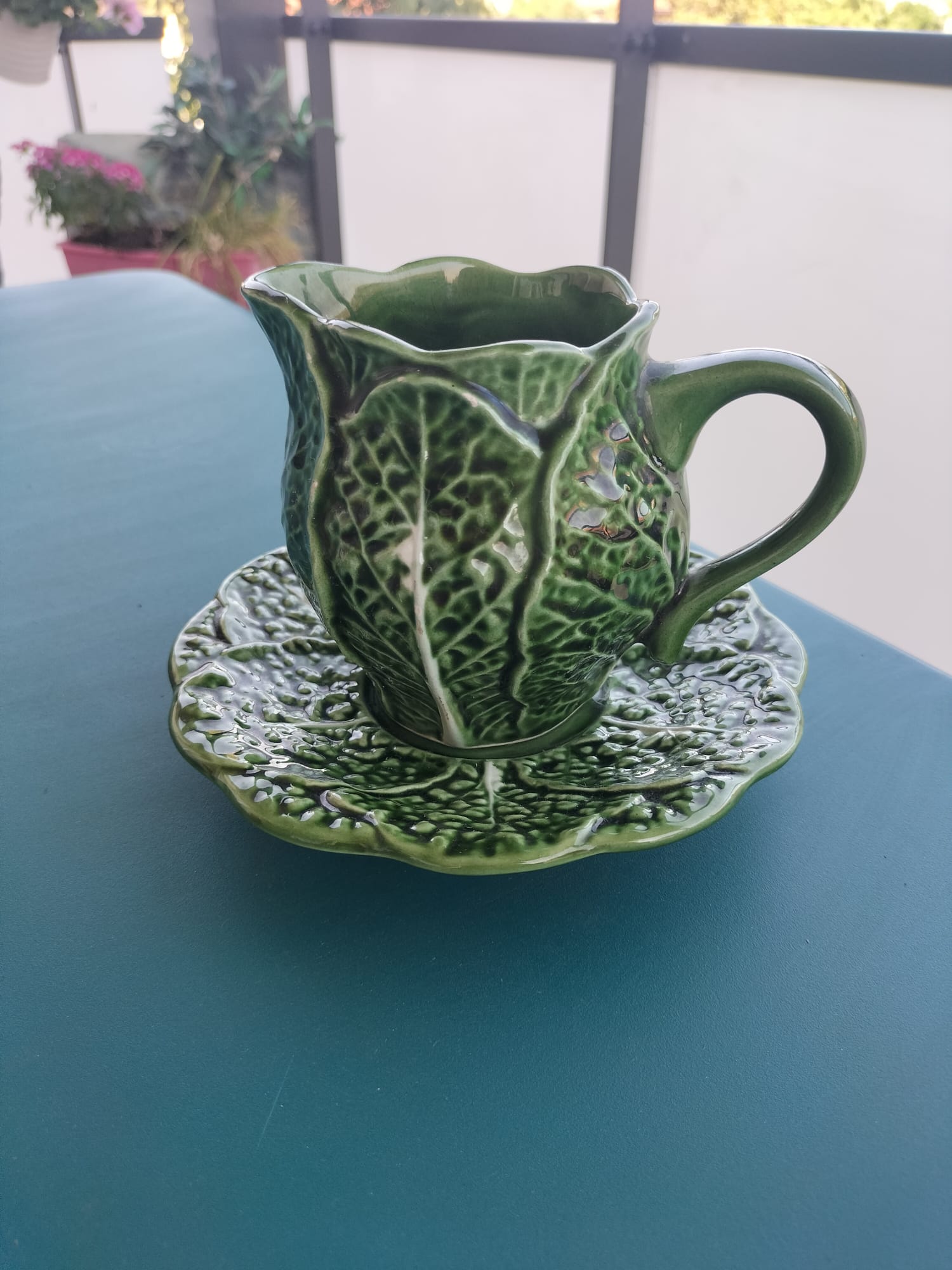 Vintage milk jug with cabbage leaf design in majolica with saucer.