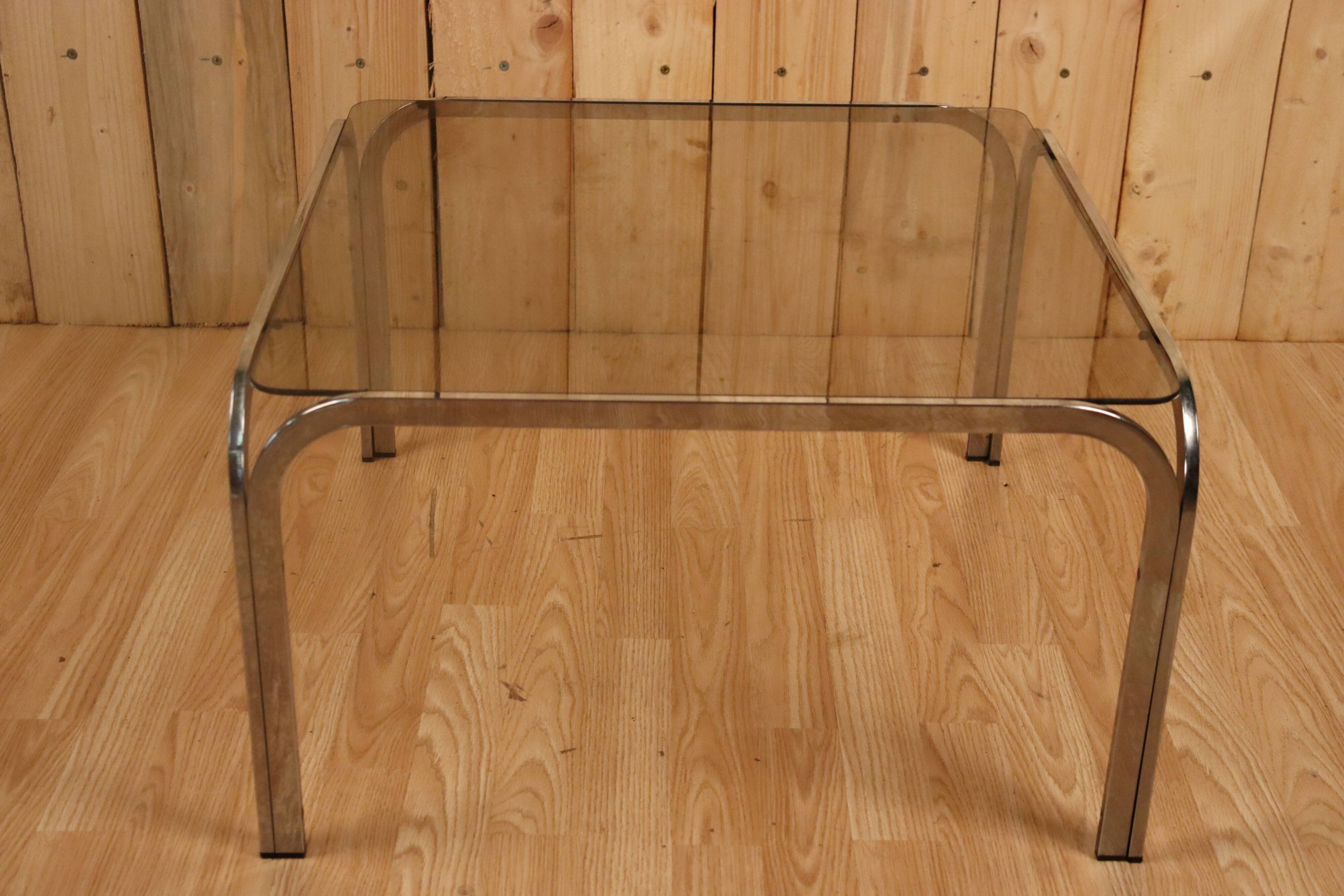 Table basse verre fumé et acier tubulaire.