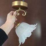 Frosted glass tulip wall sconces with brass arms.