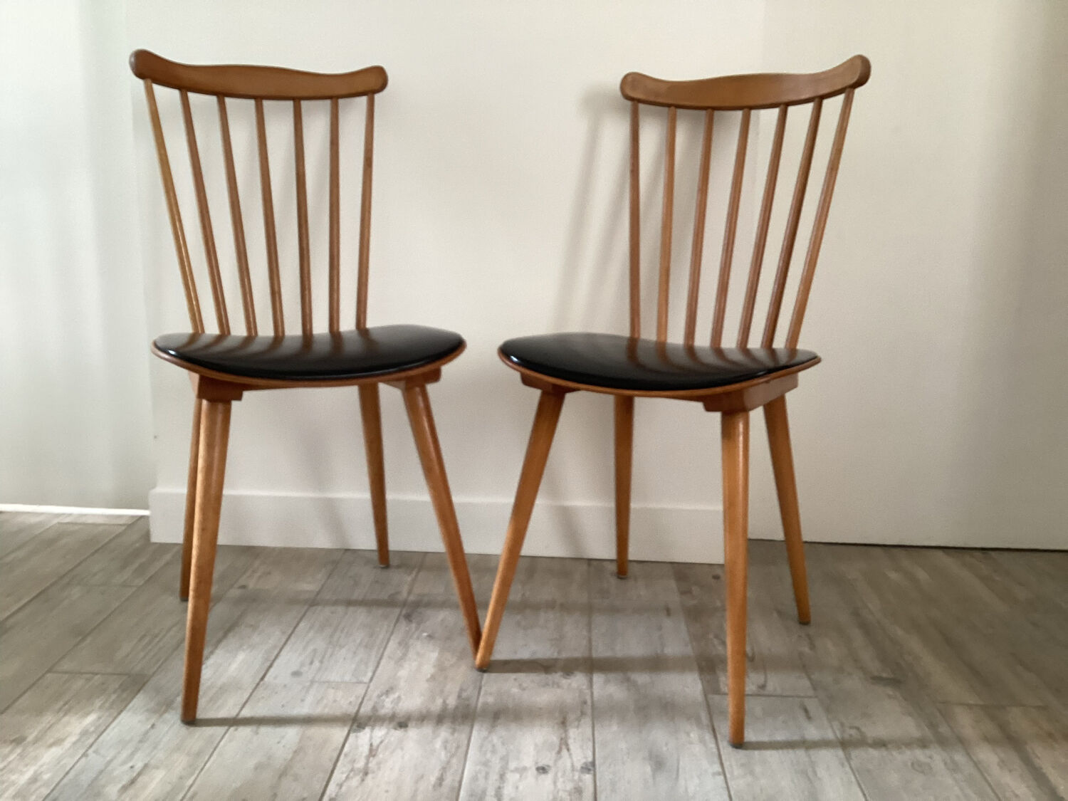 2 baumann chairs seated in imitation black leather