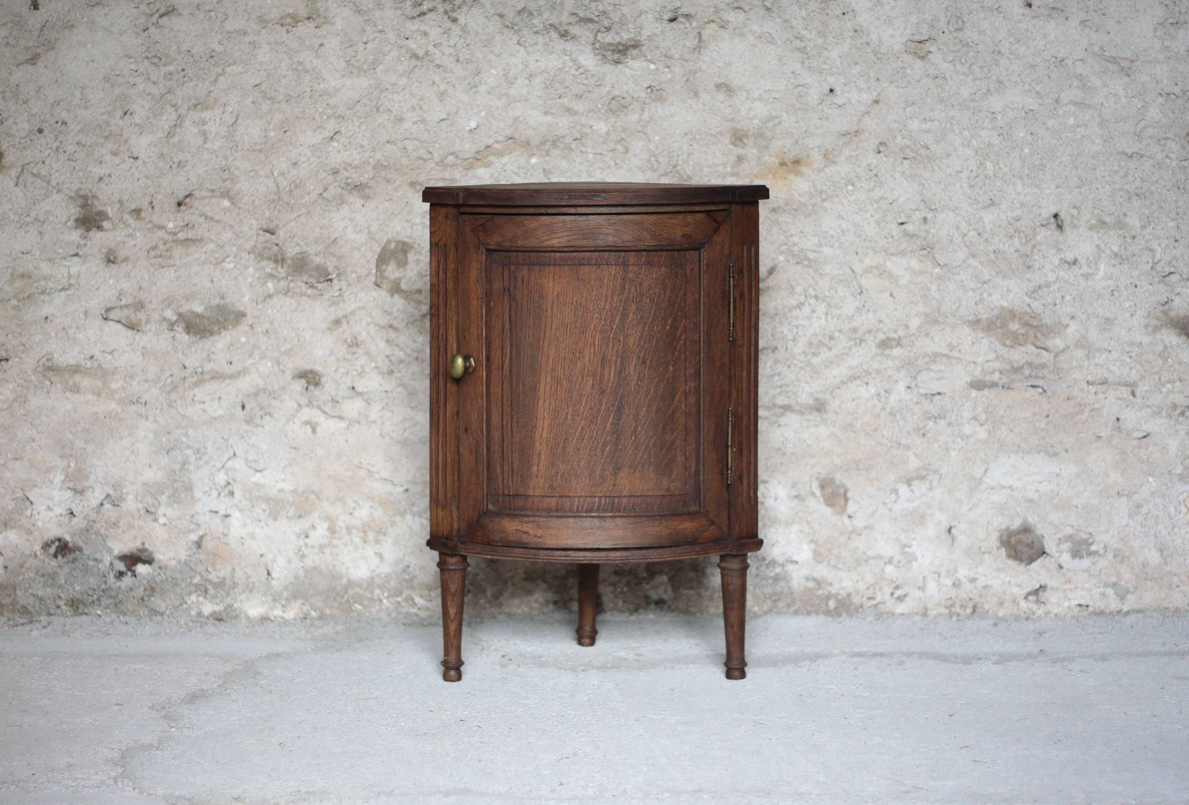 Antique wooden corner cabinet with a curved door.