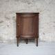 Antique wooden corner cabinet with a curved door.