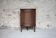 Antique wooden corner cabinet with a curved door.