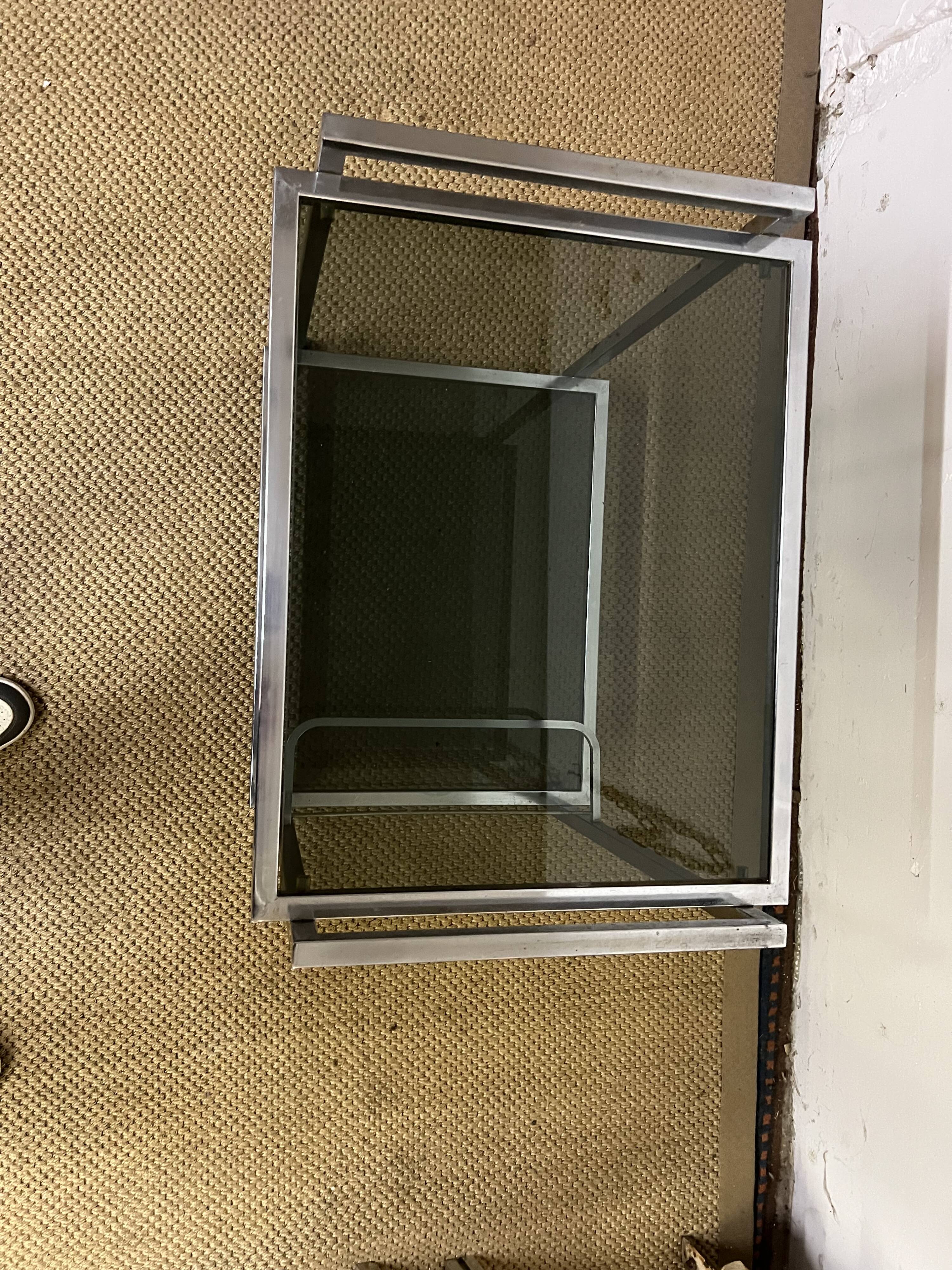 1970s coffee table in brass with a double smoked glass top.