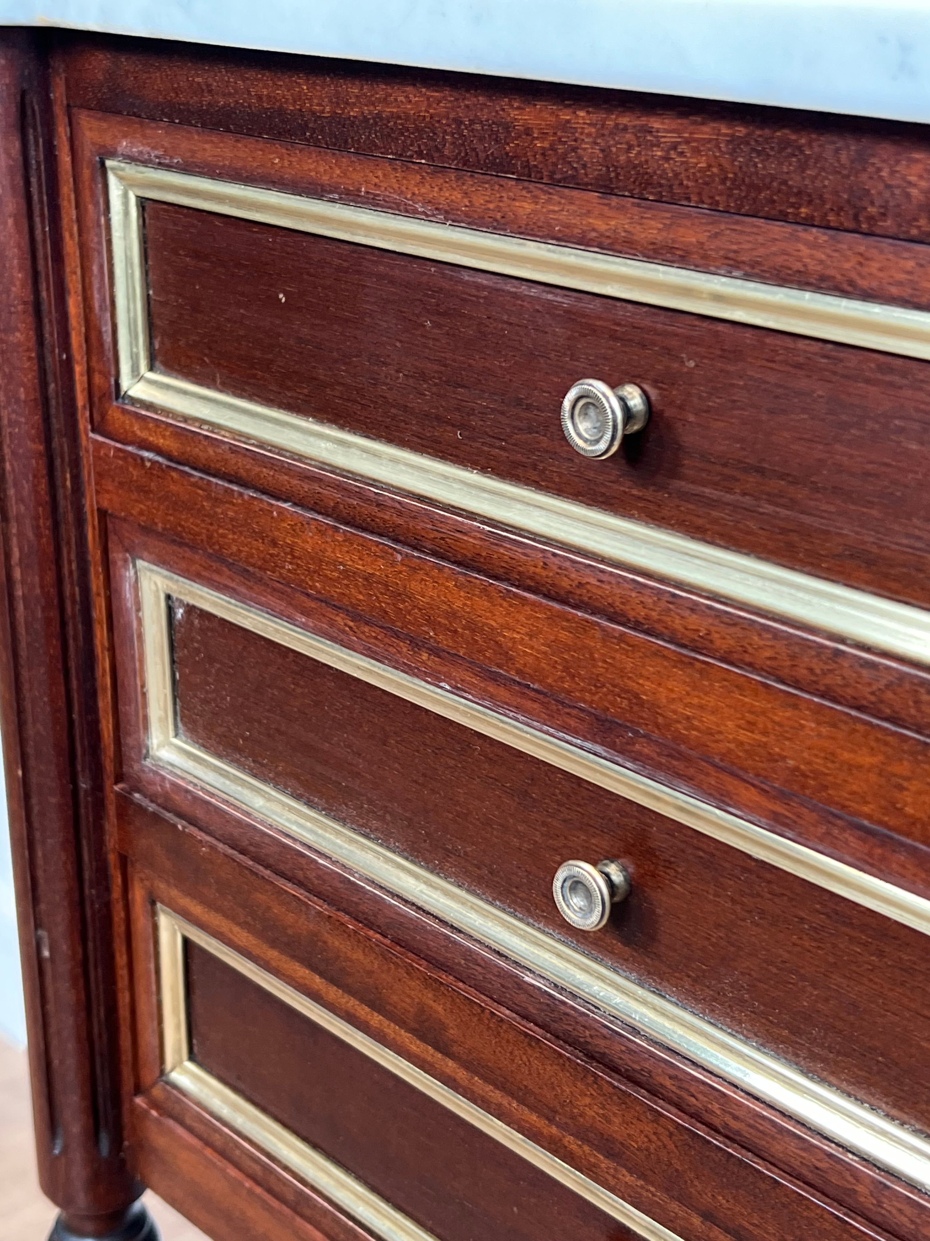 Pair of mahogany and brass side tables or bedside tables with Carrara marble tops.