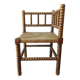 Antique corner chair by the fire with turned wood and straw seat.