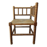 Antique corner chair by the fire with turned wood and straw seat.