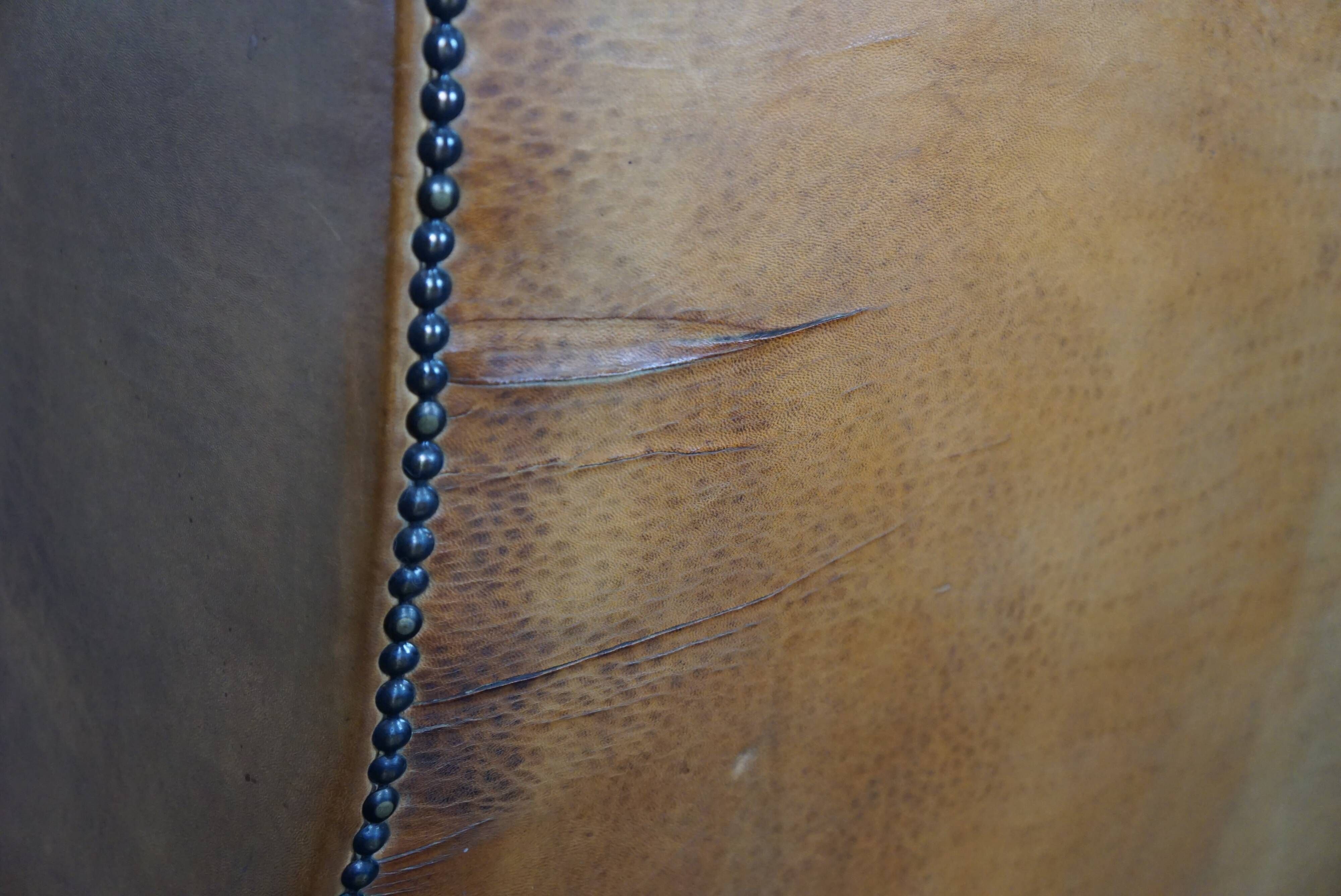 Old wingback armchair made of sheep leather in a correct condition